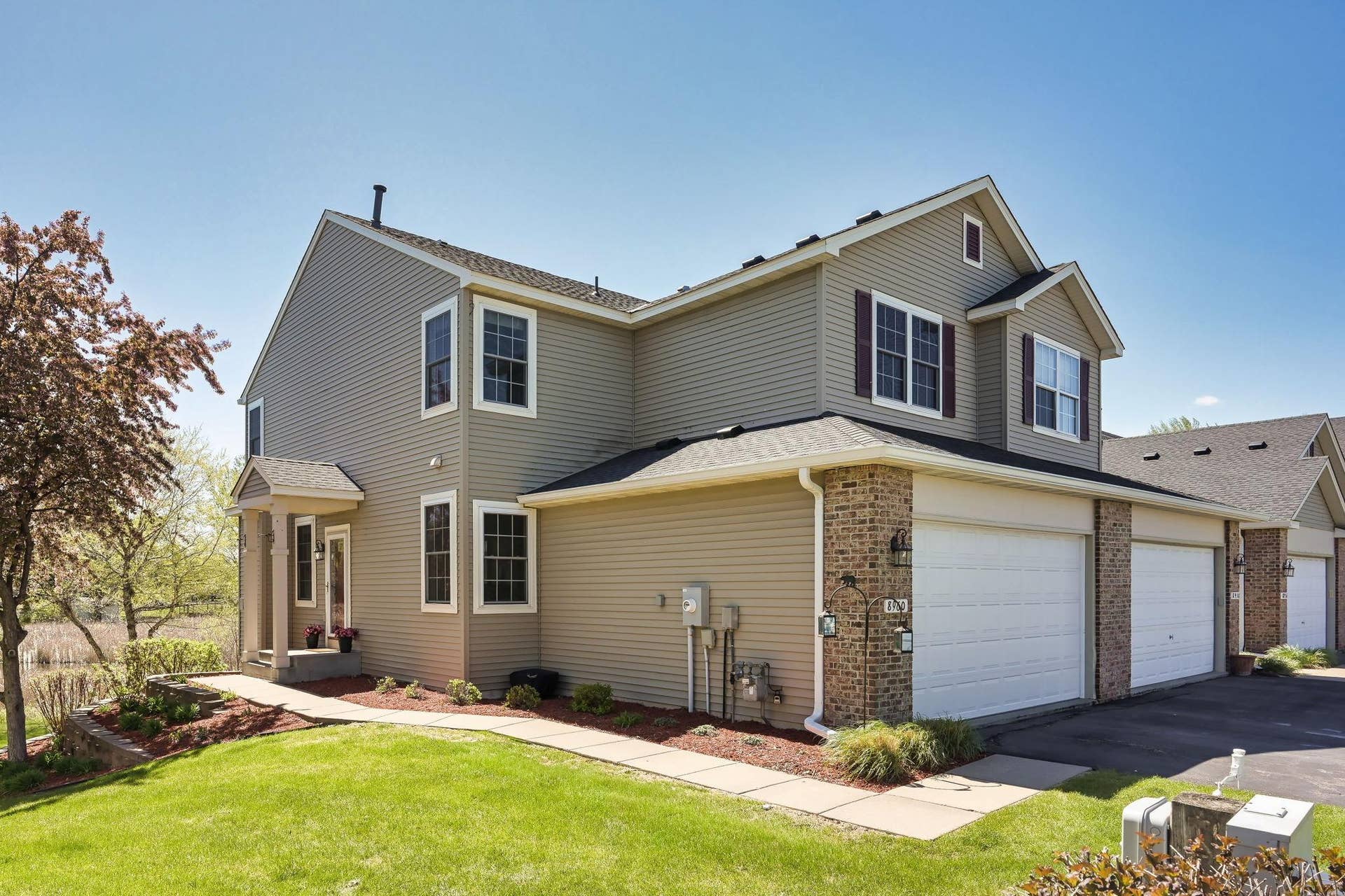 8960 Comstock Lane N, Maple Grove, MN 55311 Well-maintained end-unit townhome offers added privacy, extensive windows, mature landscaping, and scenic wetland surroundings.