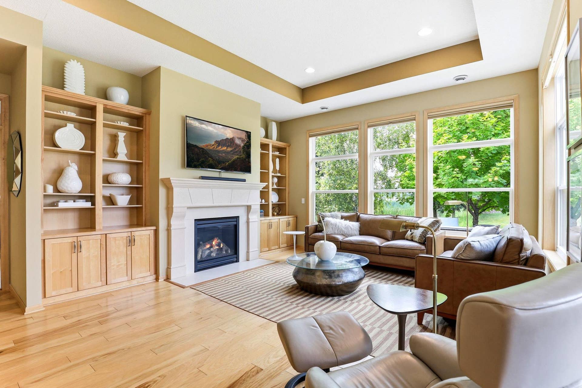 Living room centered around a glowing gas fireplace with custom built-ins for a polished, upscale focal point.