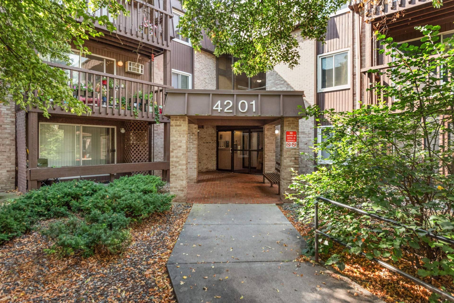 4201 Lakeside Avenue N, #113, Brooklyn Center, MN 55429 Secure, well-maintained building entrance with convenient main-level access and beautifully landscaped common grounds.