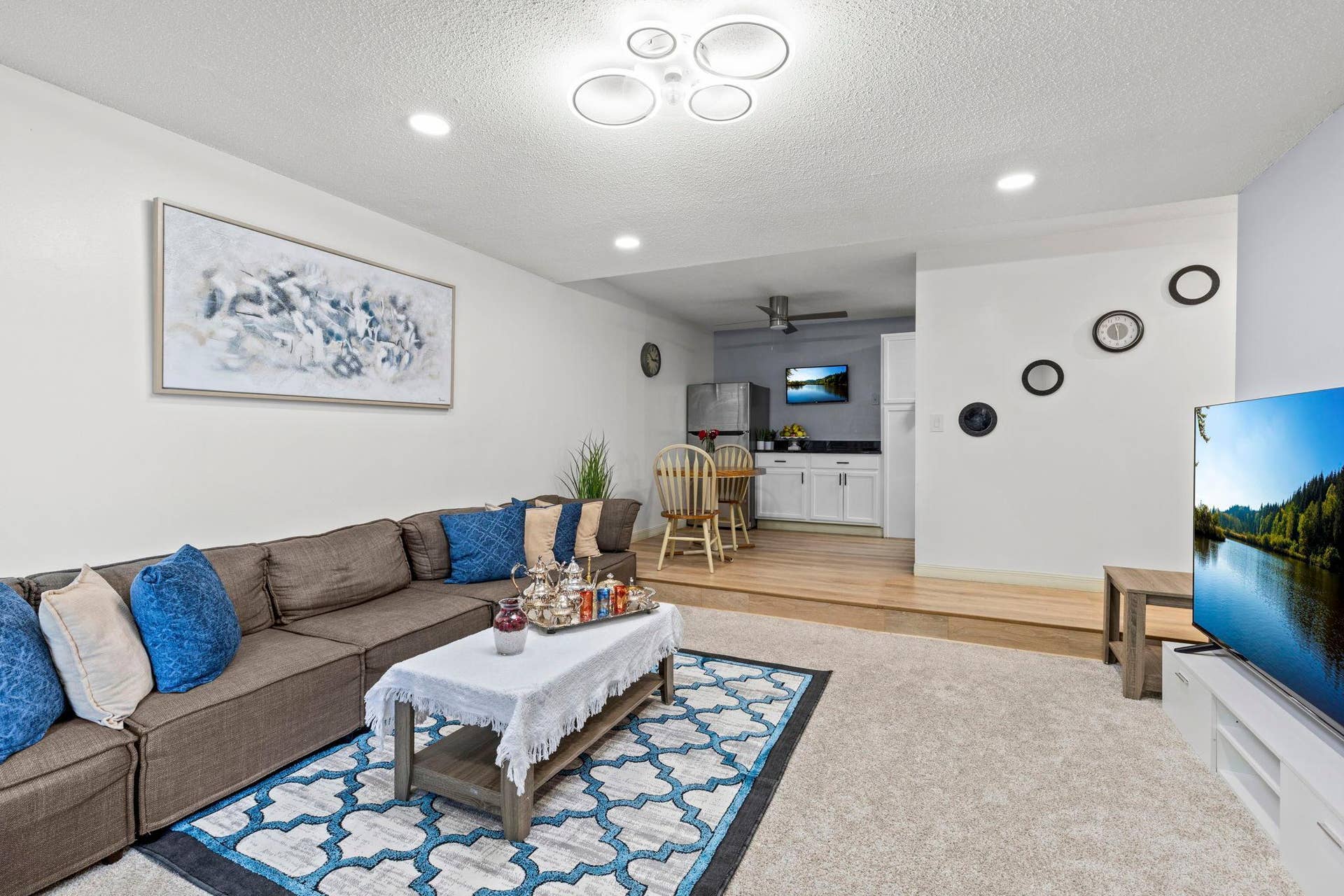4201 Lakeside Avenue N, #214, Brooklyn Center, MN 55429 The adjacent living room features cozy carpeting, recessed lighting, a unique light fixture with a discreet fan, and access to the private balcony.