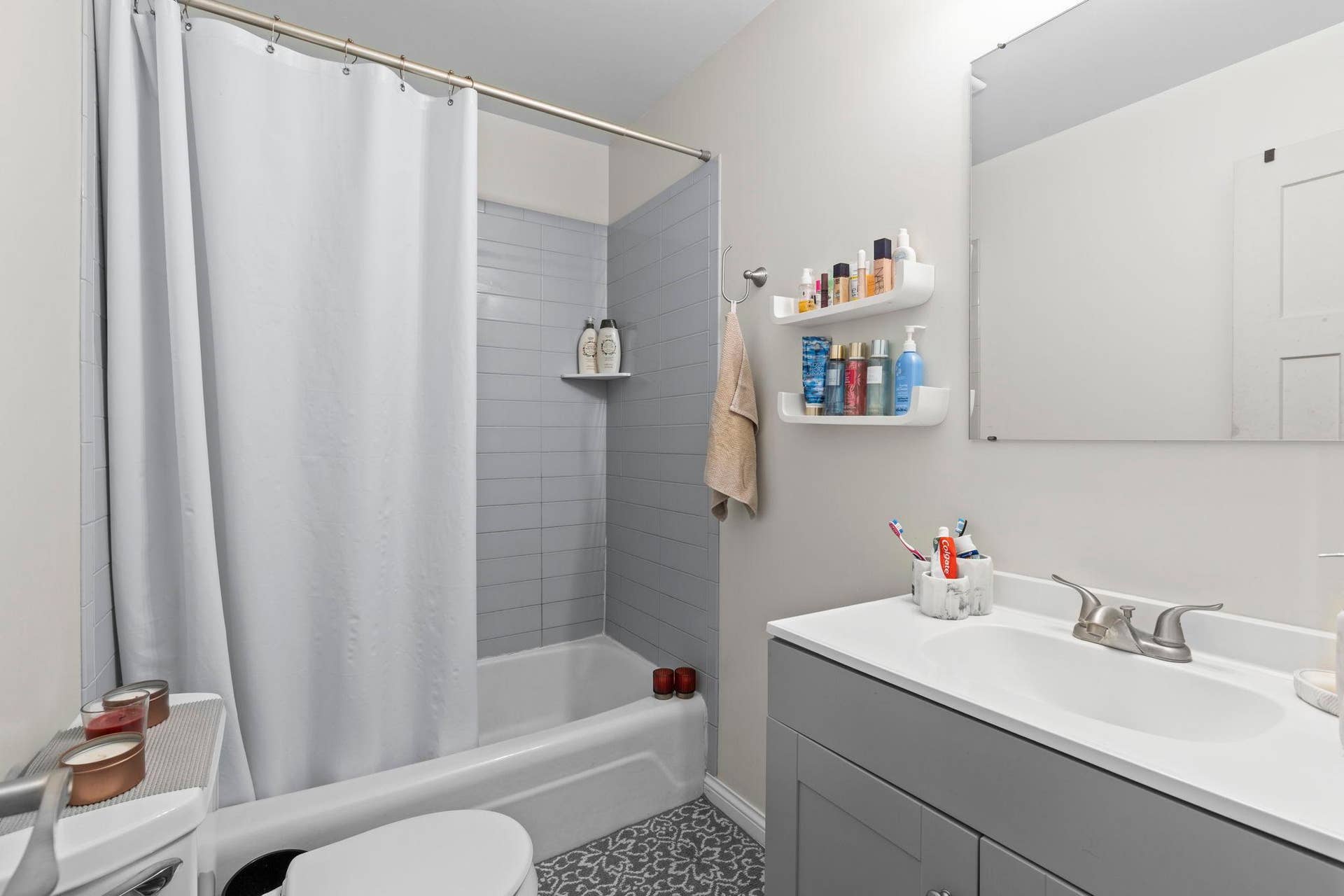 4201 Lakeside Avenue N, #214, Brooklyn Center, MN 55429 The full bathroom featuring a single vanity, tub and shower combination, and a nearby hallway linen closet for additional storage.