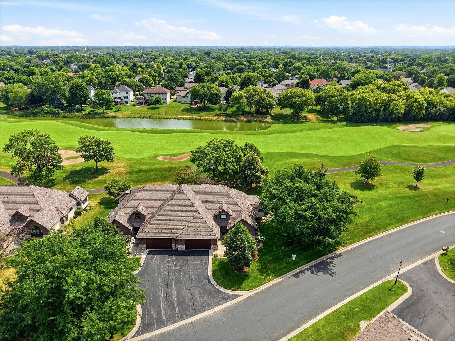 Aerial view showcasing the home's prime location overlooking the 7th fairway at Edinburgh Golf Course, with pond views beyond.
