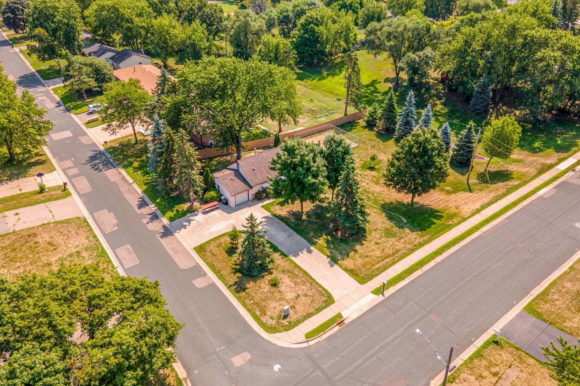 Aerial view showcases the home's desirable corner location and park-like setting, offering an impressive amount of outdoor space.