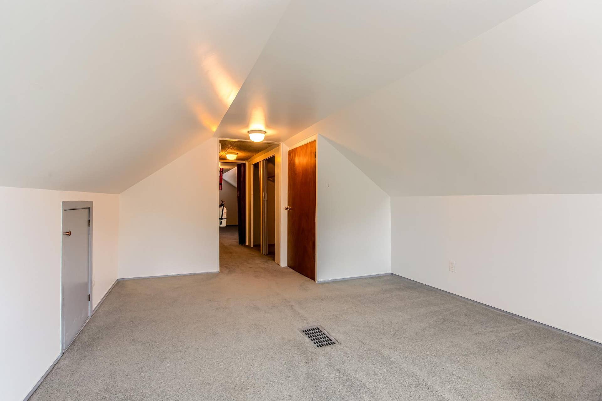 Another view of the upper-level bedroom highlights its generous proportions and flexible layout.