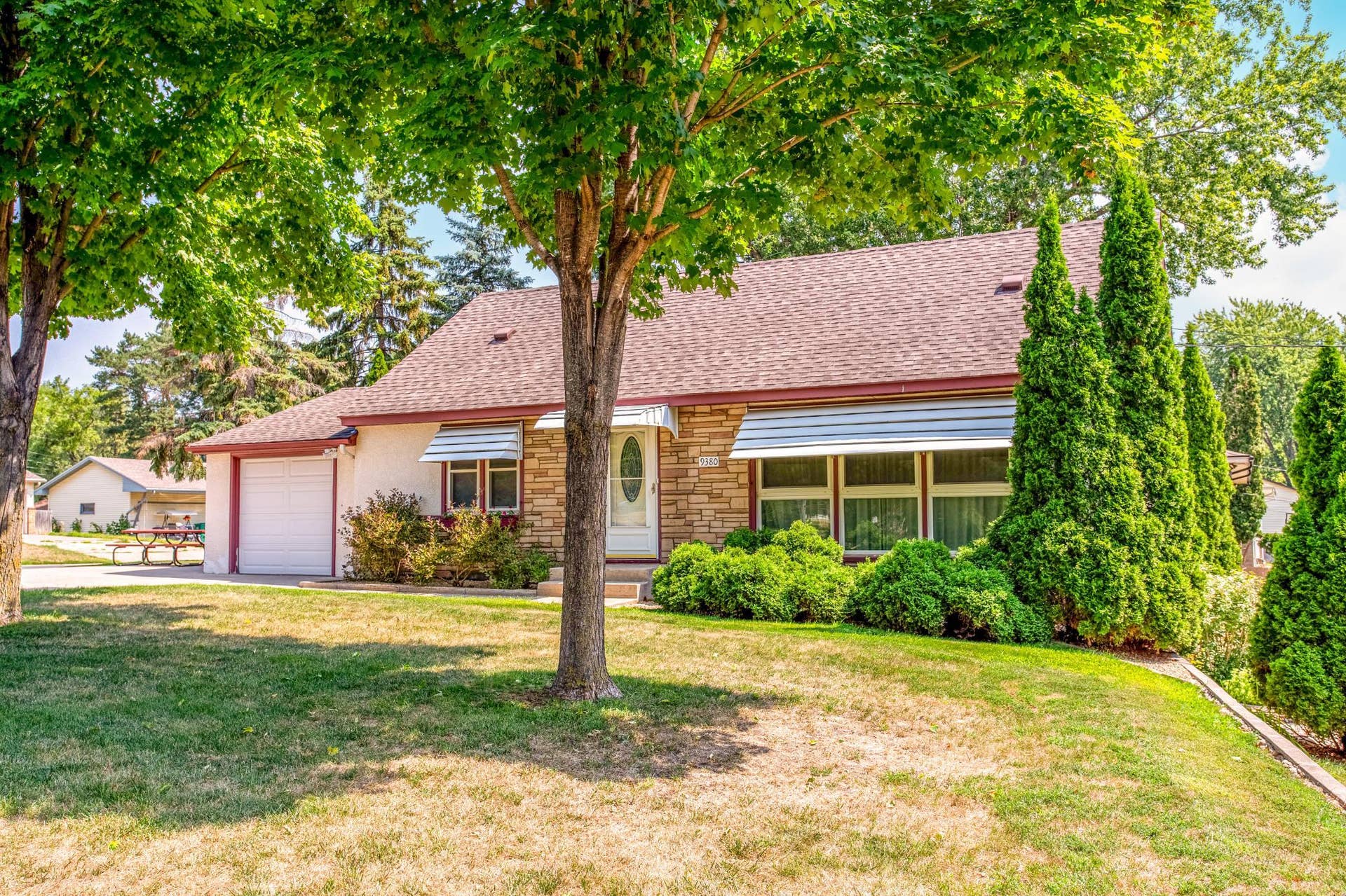 Another inviting view of the home's charming exterior, framed by mature trees and manicured landscaping on this prime corner lot.
