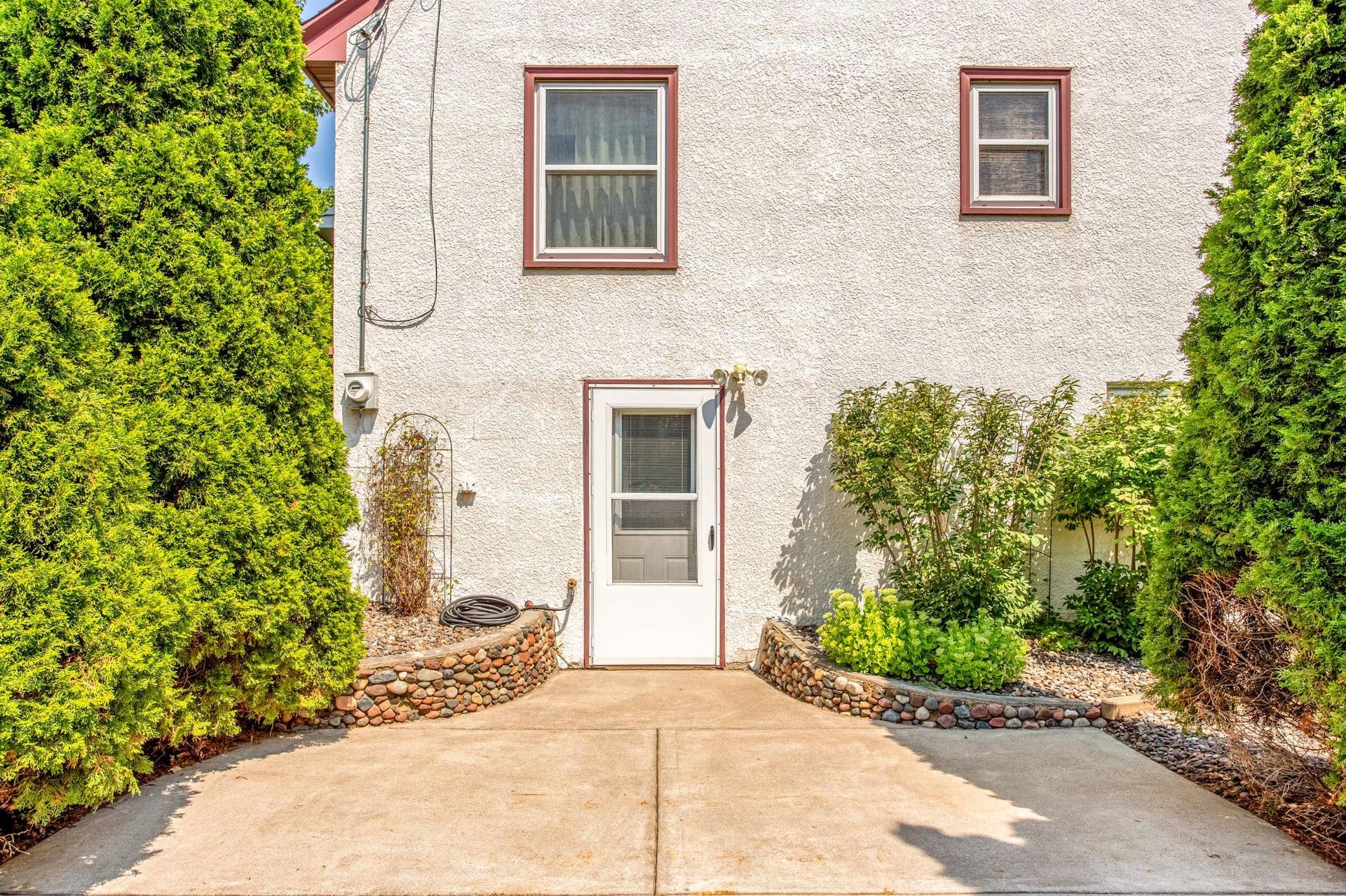 Surrounded by lush Arborvitae and attractive river-rock landscaping, the private patio offers an intimate outdoor retreat.
