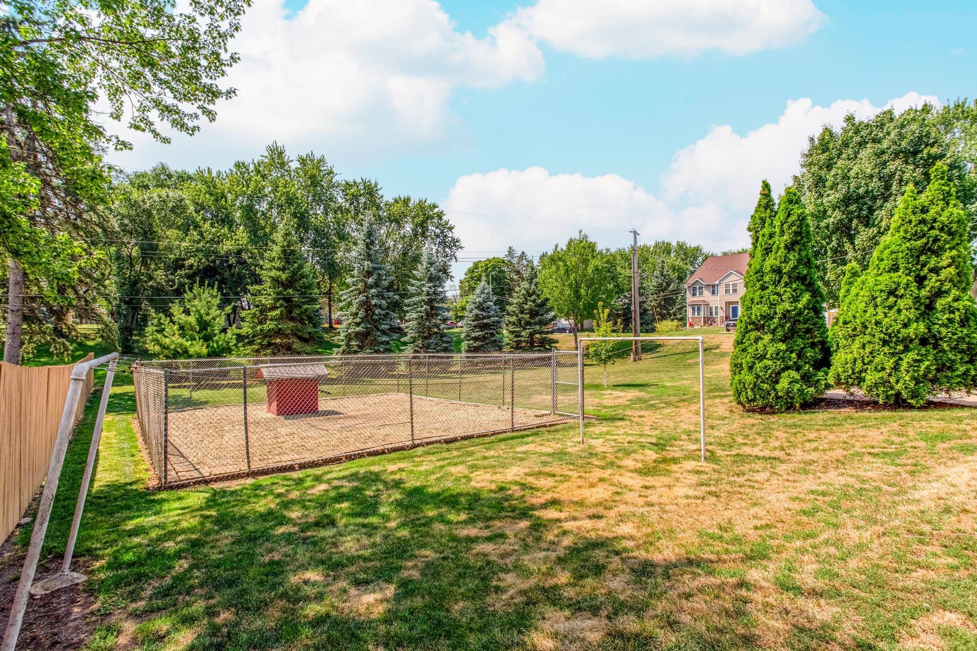 Another view of the spacious double lot highlights the generous green space and mature landscaping surrounding the property.