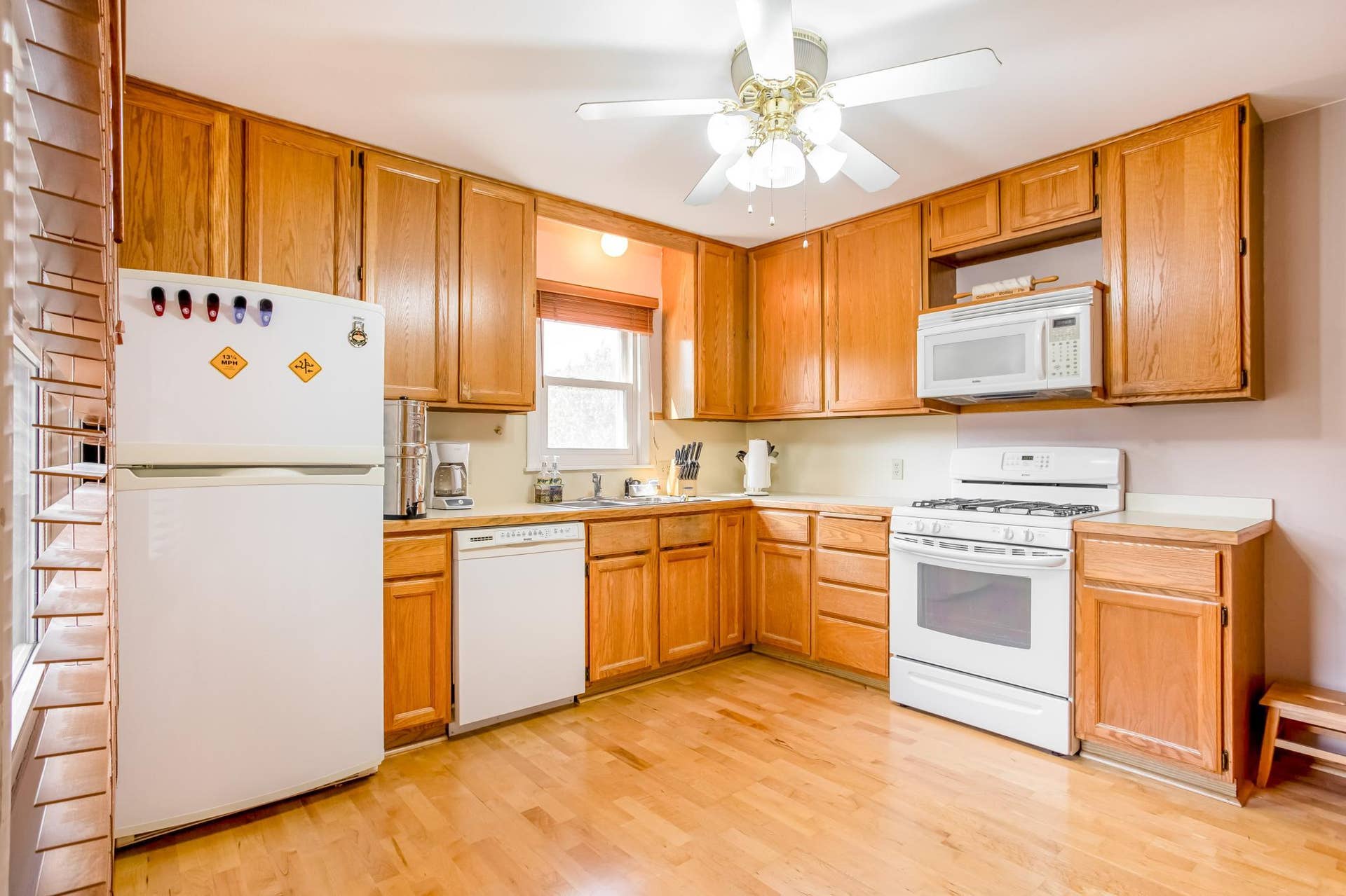 Functional kitchen offers ample cabinet and counter space, hardwood flooring, and plenty of natural light for a warm and welcoming feel.