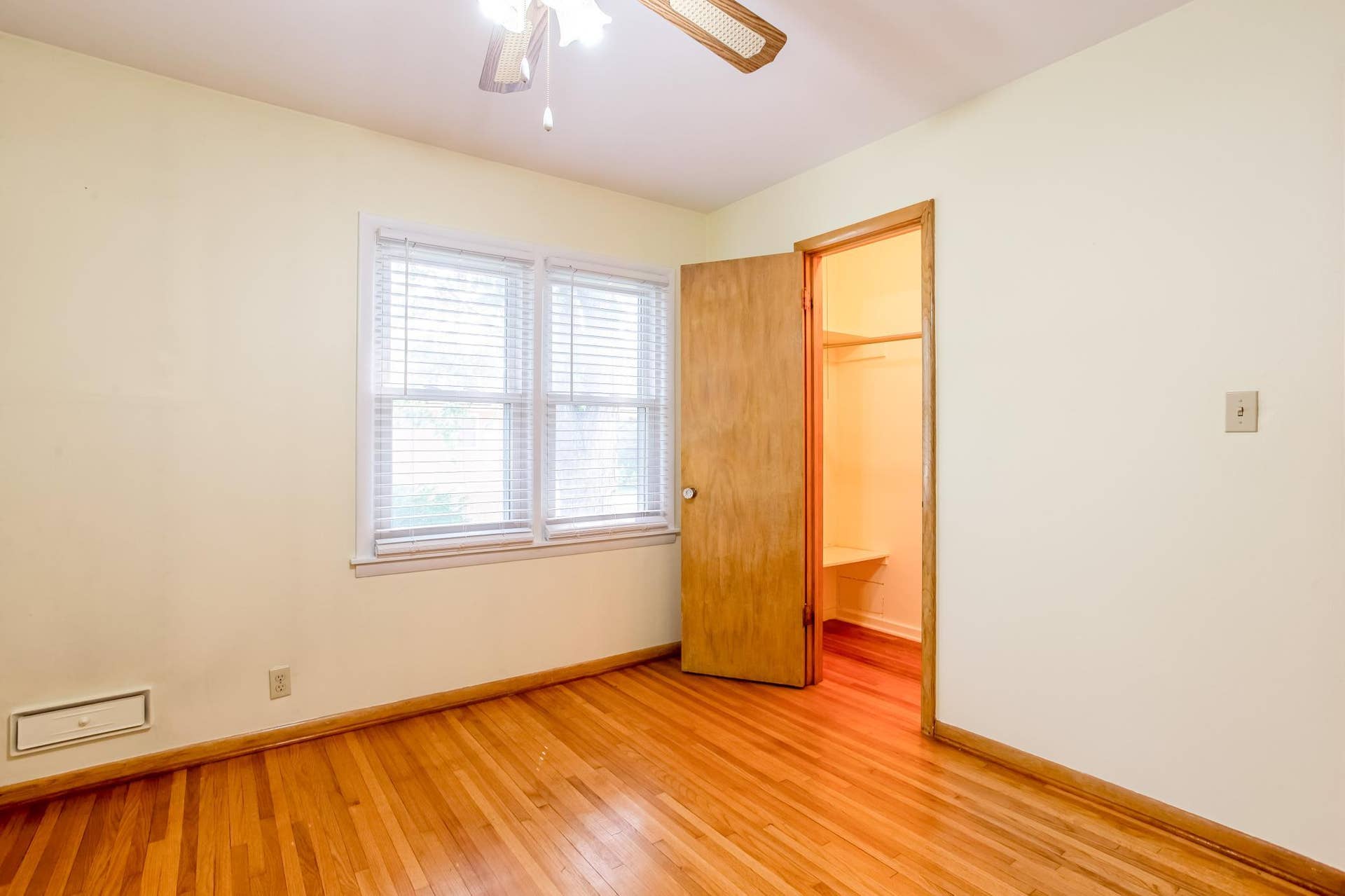 Another view of the main-level bedroom showcases the hardwood floors, ample closet space, and bright, comfortable layout.