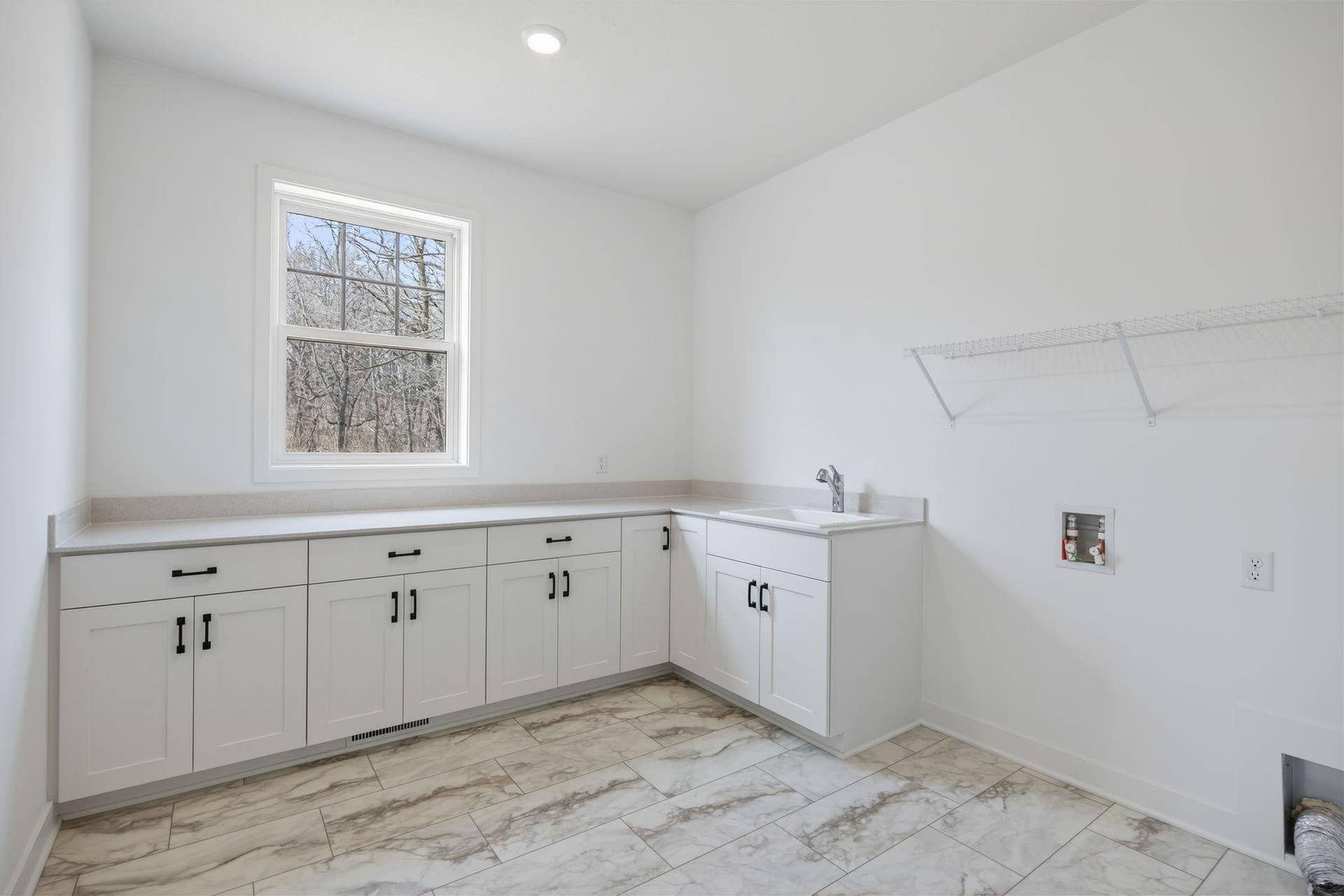 11180 Masters Street N, Lake Elmo, MN 55042 (Photo of a similar home, actual finishes may vary) Situated in a discreet corner on the first floor, this large laundry room provides ample space to complete daily household chores and other organizational tasks.