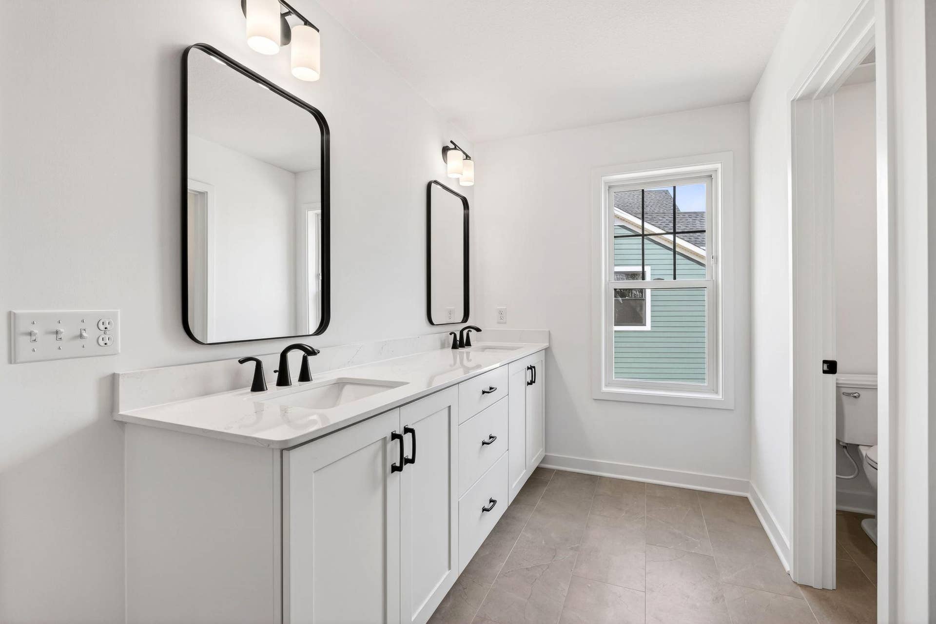 11180 Masters Street N, Lake Elmo, MN 55042 (Photo of a similar home, actual finishes may vary) Double sinks, Moen brushed-nickel faucets and quartz countertops gleam in the owners suite bathroom