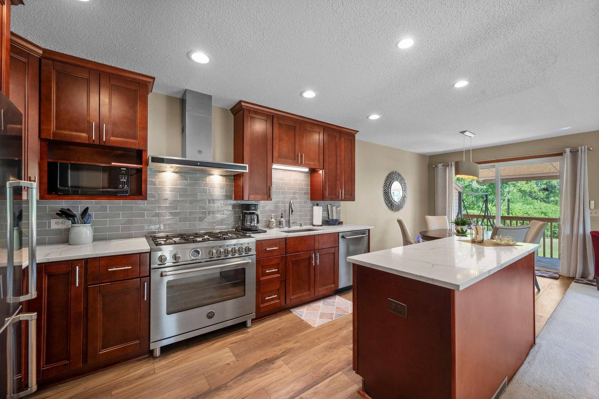 14333 91st Place N, Maple Grove, MN 55369 The remodeled kitchen features tons of cherry cabinetry, quartz countertops and pretty backsplash.