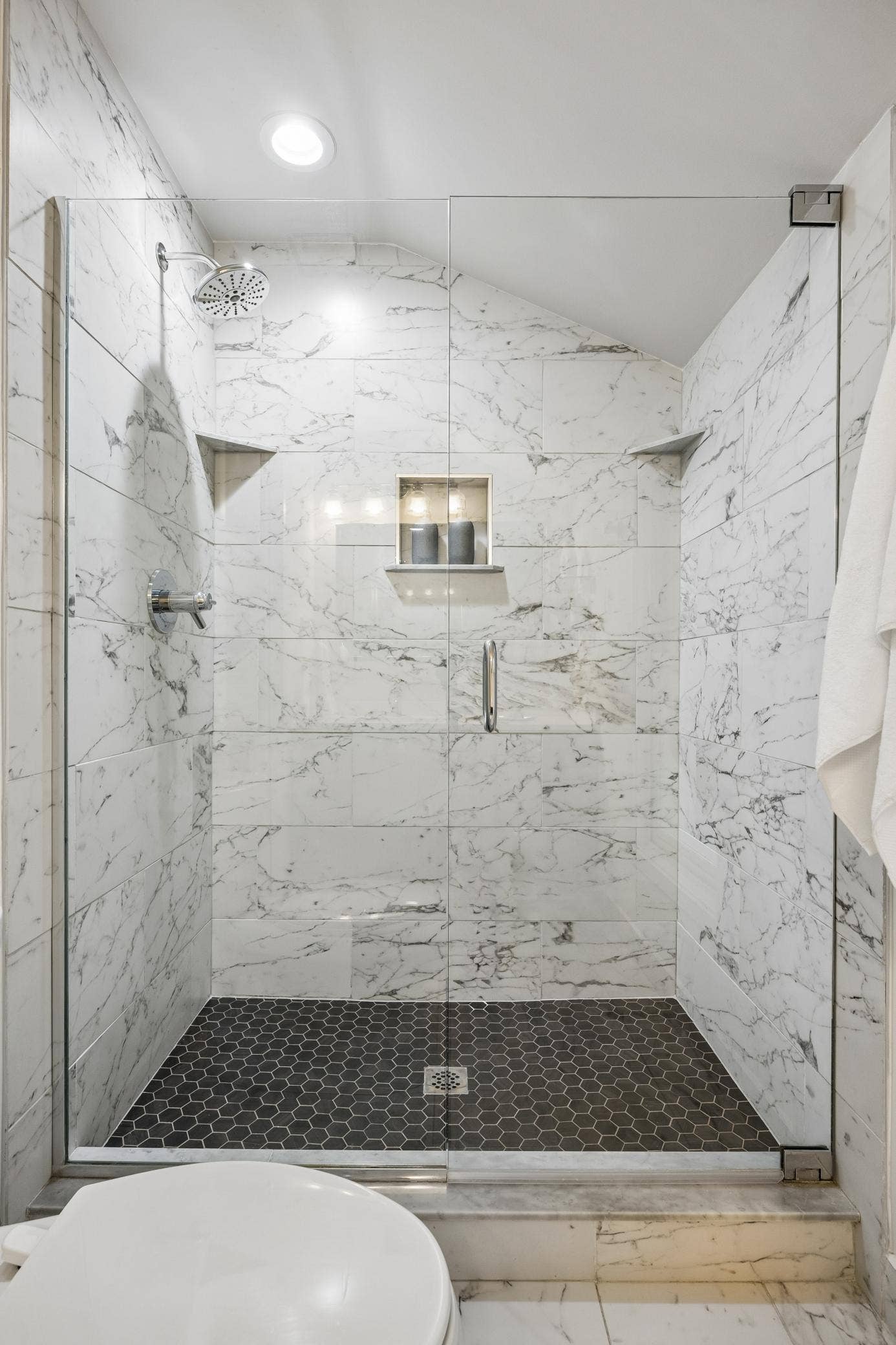 2637 1/2 Humboldt Avenue S, 21, Minneapolis, MN 55408 Primary bath with a glass-enclosed shower, elegant tiled walls, and hexagon-tiled shower floor.