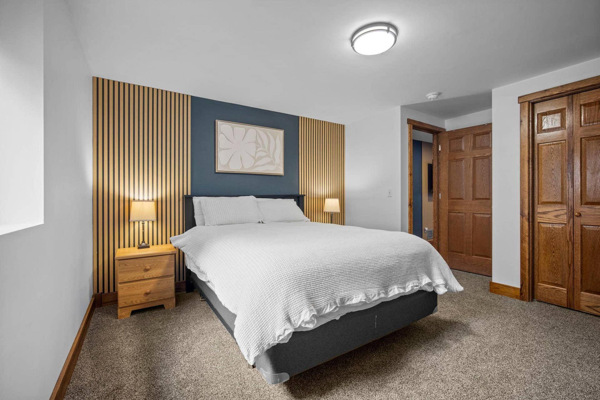 The finished lower level includes a spacious fifth bedroom featuring an egress window and elegant wall panel accents.