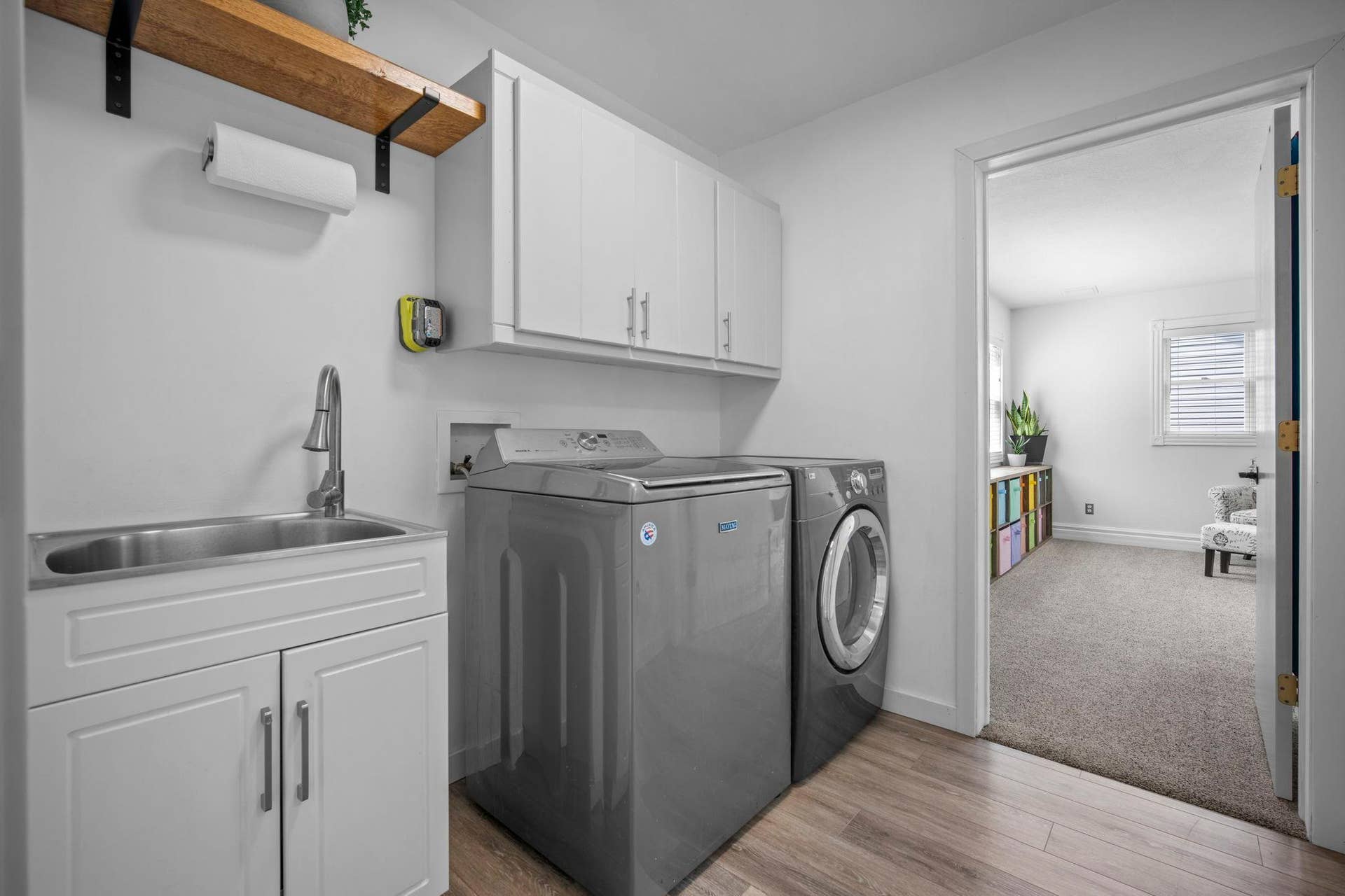 Convenient main level laundry with LVP flooring and built-in storage.