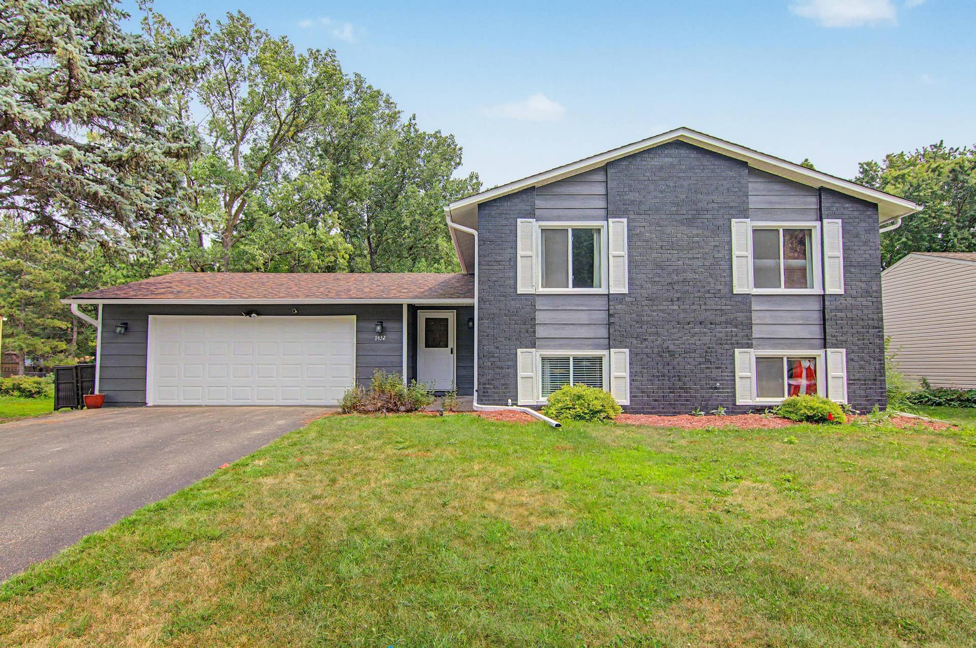7432 Drew Avenue N, Brooklyn Park, MN 55443 Front exterior featuring a freshly painted faade and attached two-car garage.