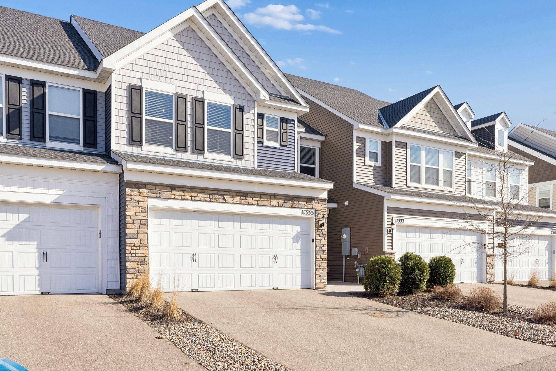 Front exterior view from the left highlighting well-maintained landscaping and welcoming townhouse entry.