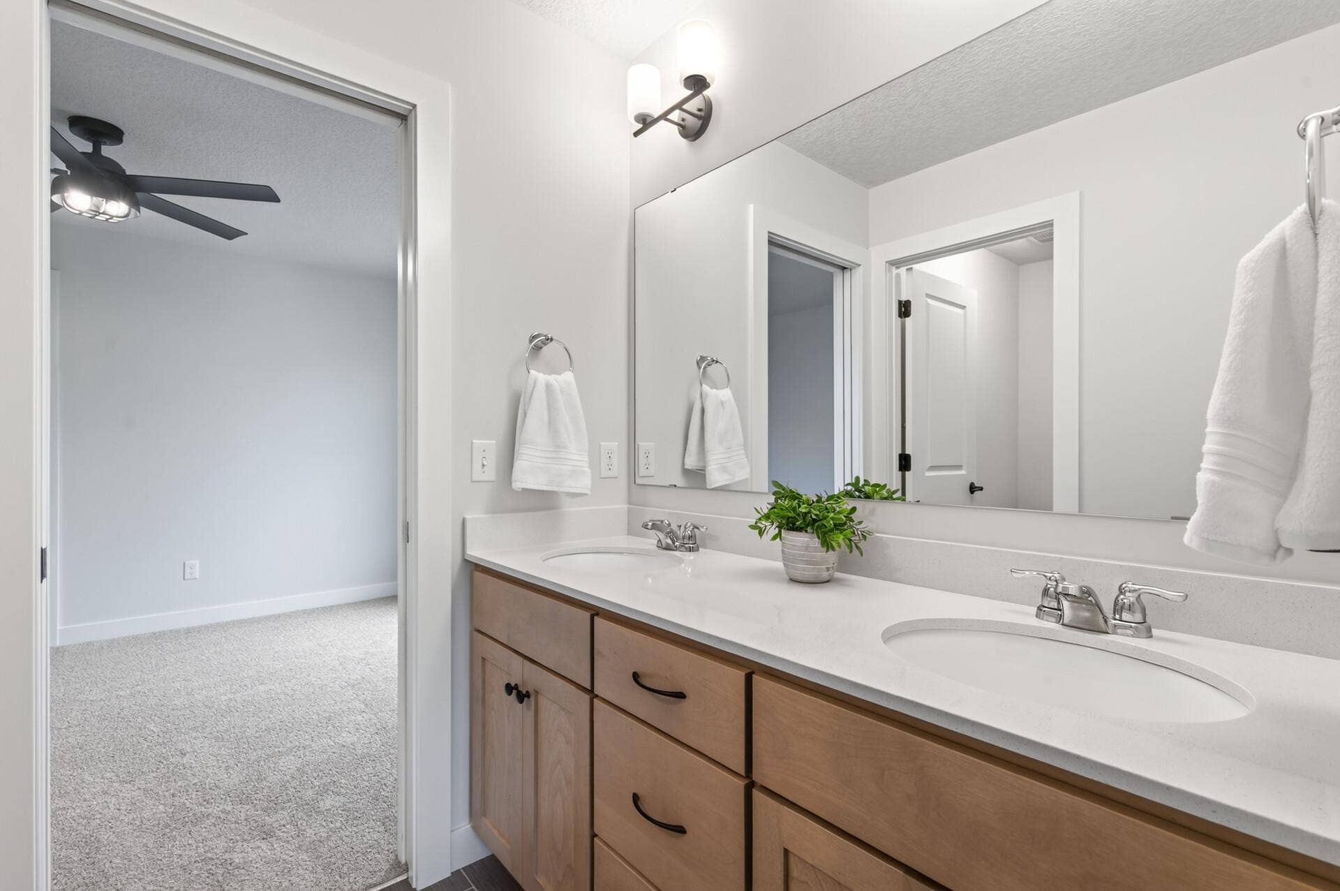 9960 Arrowwood Trail, Woodbury, MN 55129 Well-designed Jack-and-Jill bathroom includes dual sinks and a separate private tub/toilet area, balancing shared space with personal privacy.