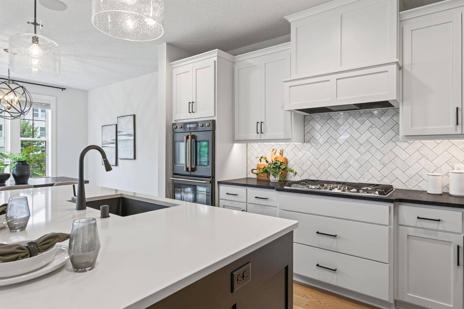 9960 Arrowwood Trail, Woodbury, MN 55129 This cooktop nook has it all: crisp white enameled counters, a gas cooktop for precision cooking, convenient pull-out drawers for pots and pans, an eye-catching tile backsplash, and the double oven within easy reach.