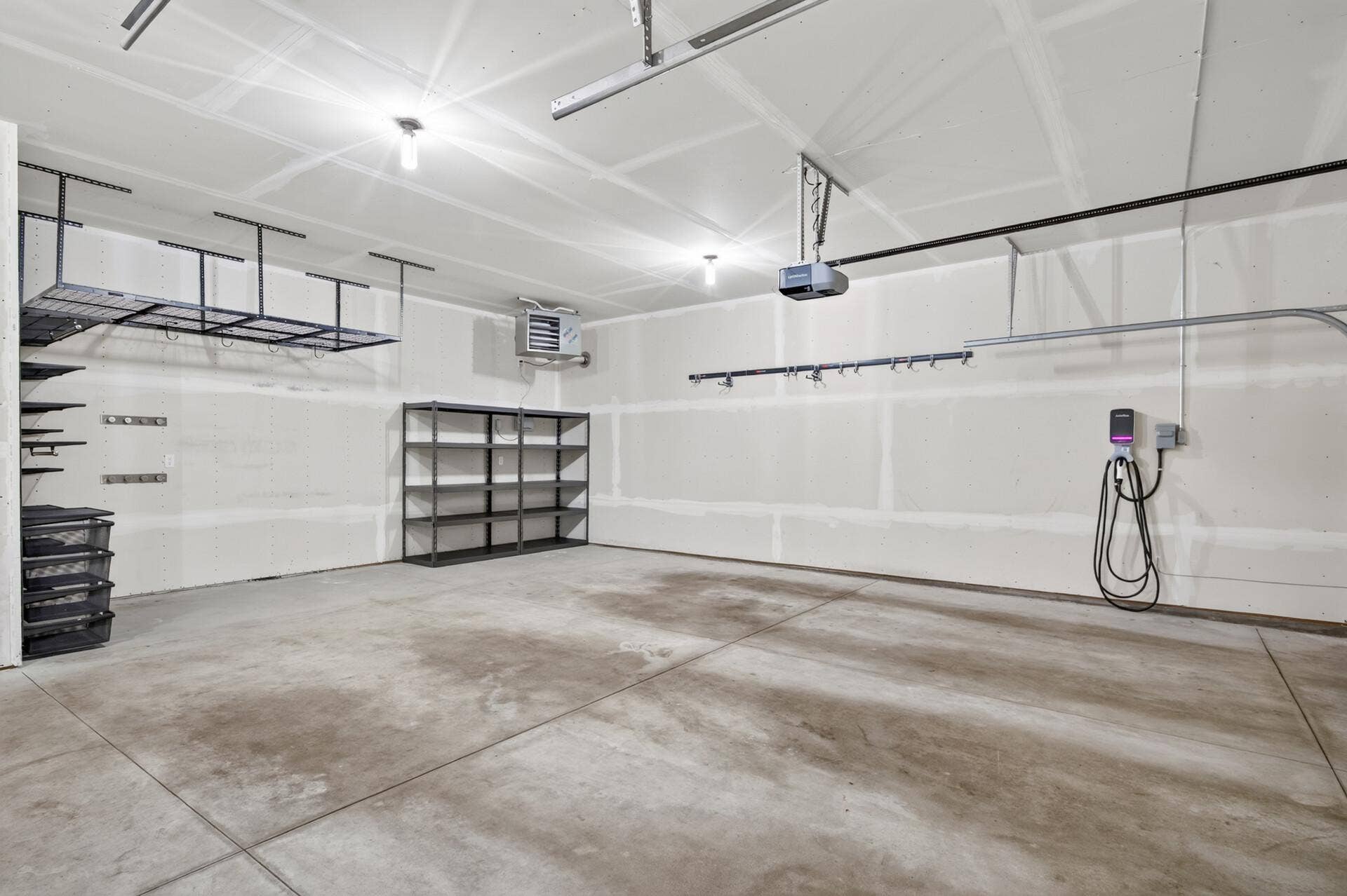 9960 Arrowwood Trail, Woodbury, MN 55129 A true car enthusiast's dream; this insulated and heated 3-car garage offers extra-tall ceilings, an included EV charger, dual garage door openers, and included metal storage racks.