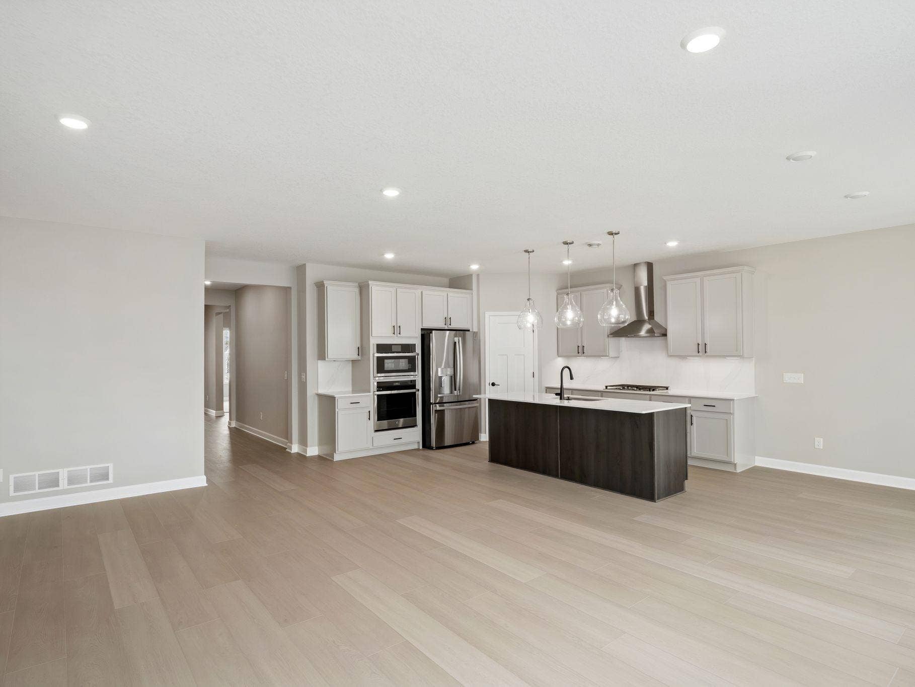 The center island with an undermount stainless steel sink and multicycle dishwasher effortlessly flows to the rest of the home for effortless living