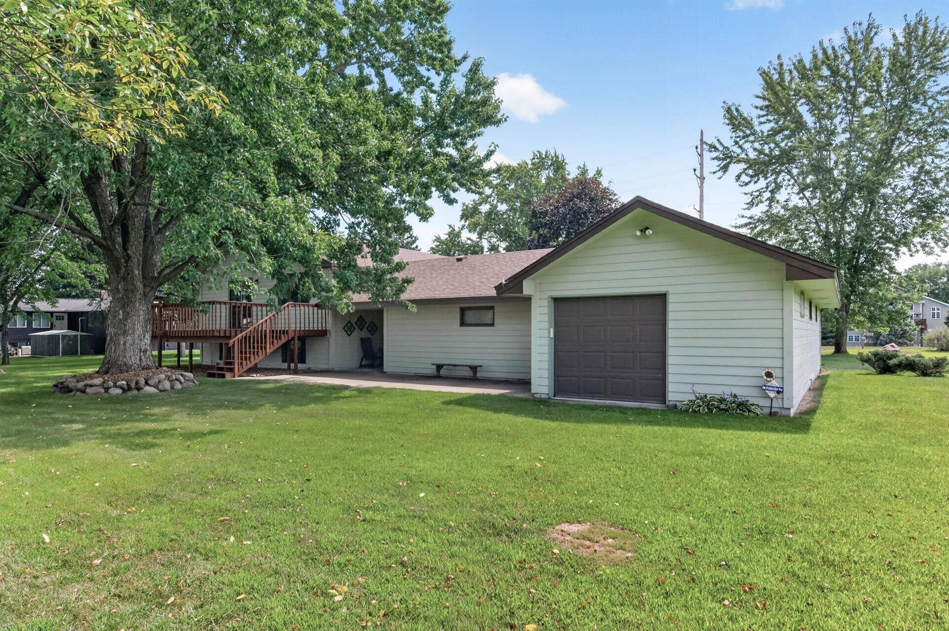 3800 101st Avenue N, Brooklyn Park, MN 55443 A backyard view showing the deck, concrete patio and garage door out the back of the outside garage stall.