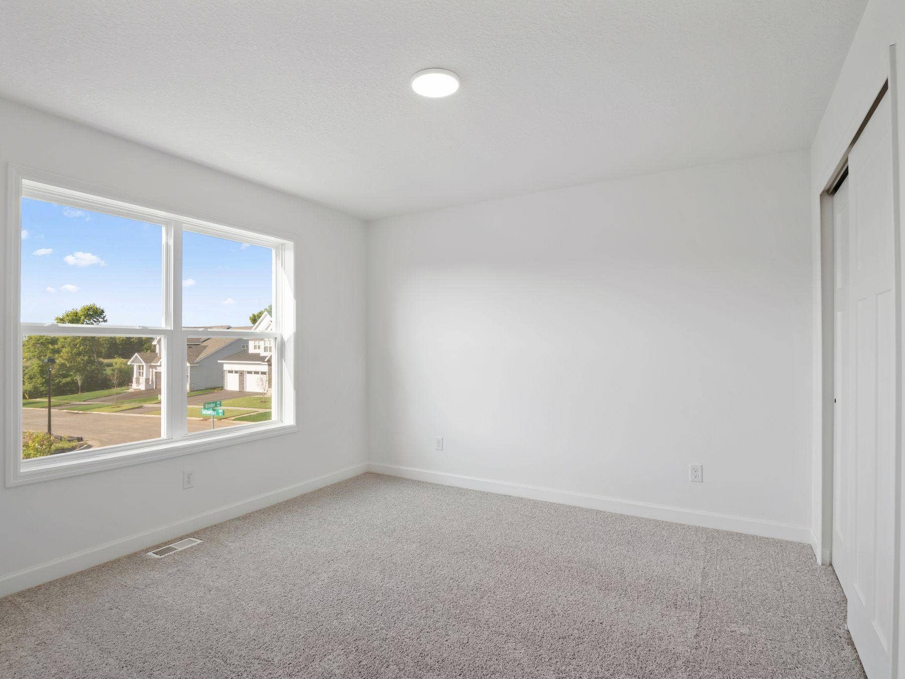 This secondary bedroom is sequestered from the rest of the first floor living spaces, creating a quiet environment ideal for remote work or a guest suite.