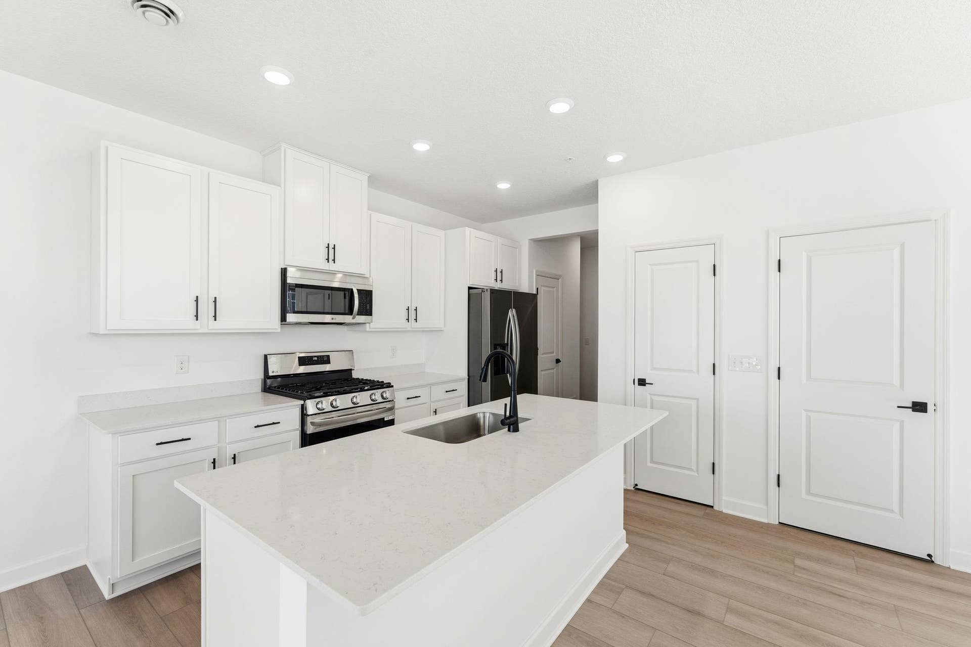 10551 Harbor Lane N, Maple Grove, MN 55369 (Photo of a similar home, actual finishes may vary) This chef-ready kitchen is designed to accommodate modern living, with a multiuse center island to add food prep and seating space, gleaming quartz countertops and abundant cabinetry room.