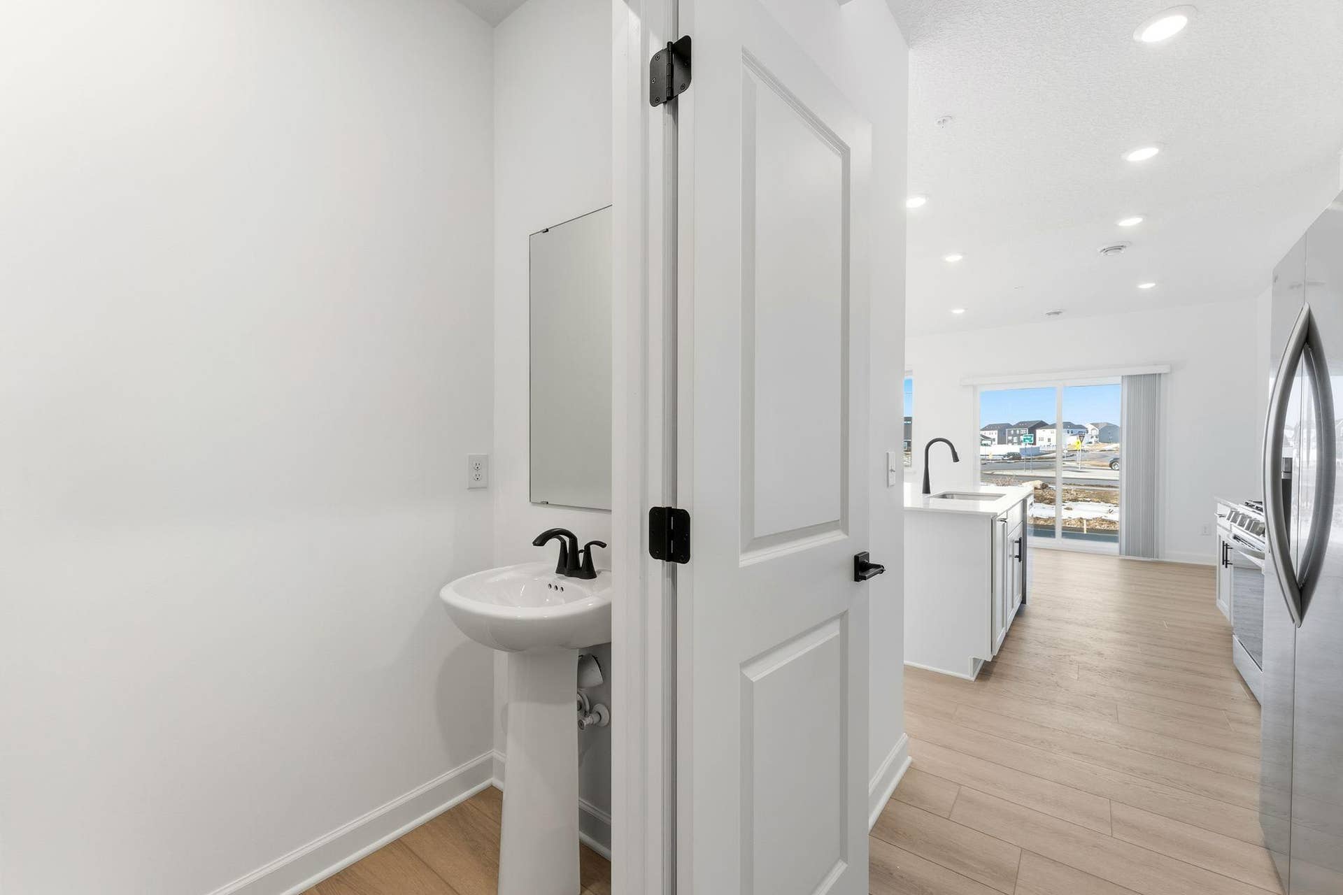10551 Harbor Lane N, Maple Grove, MN 55369 (Photo of a similar home, actual finishes may vary) Situated directly off the kitchen, this powder room optimizes the first-floor main living area for residents and guests alike.