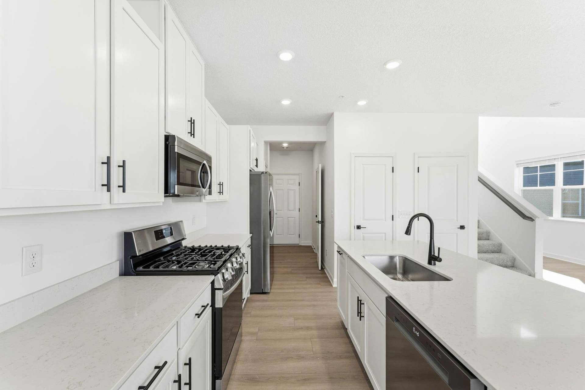 10551 Harbor Lane N, Maple Grove, MN 55369 (Photo of a similar home, actual finishes may vary) A subway tile backsplash atop the 5-burner gas cooktop with an overhead microwave meets style with functionality