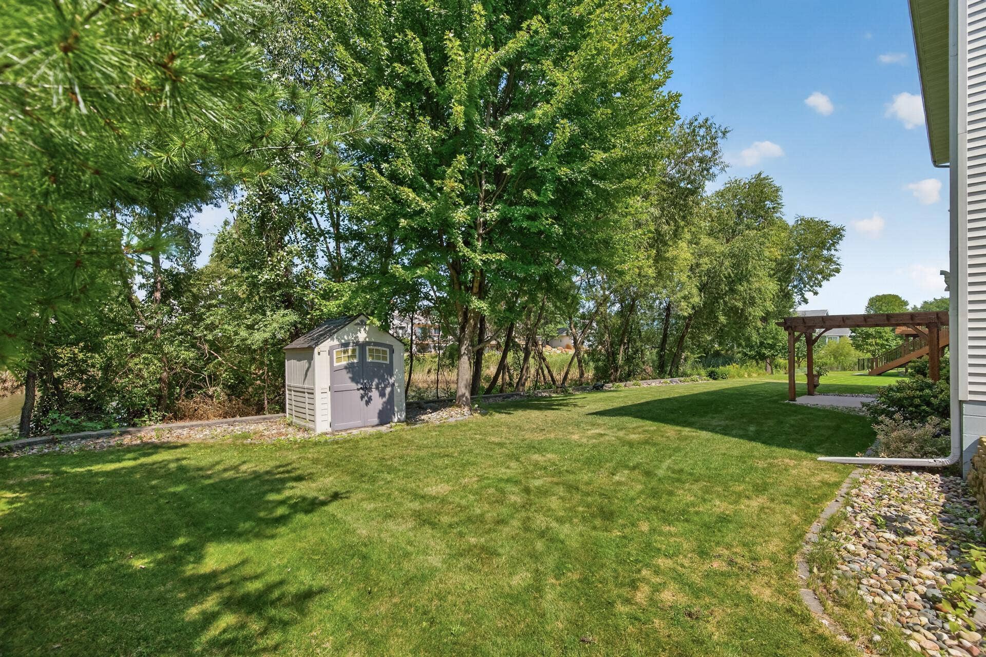 10548 Noble Circle N, Brooklyn Park, MN 55443 Backyard: Oversized backyard overlooking the pond, offering peaceful views and plenty of outdoor space.
