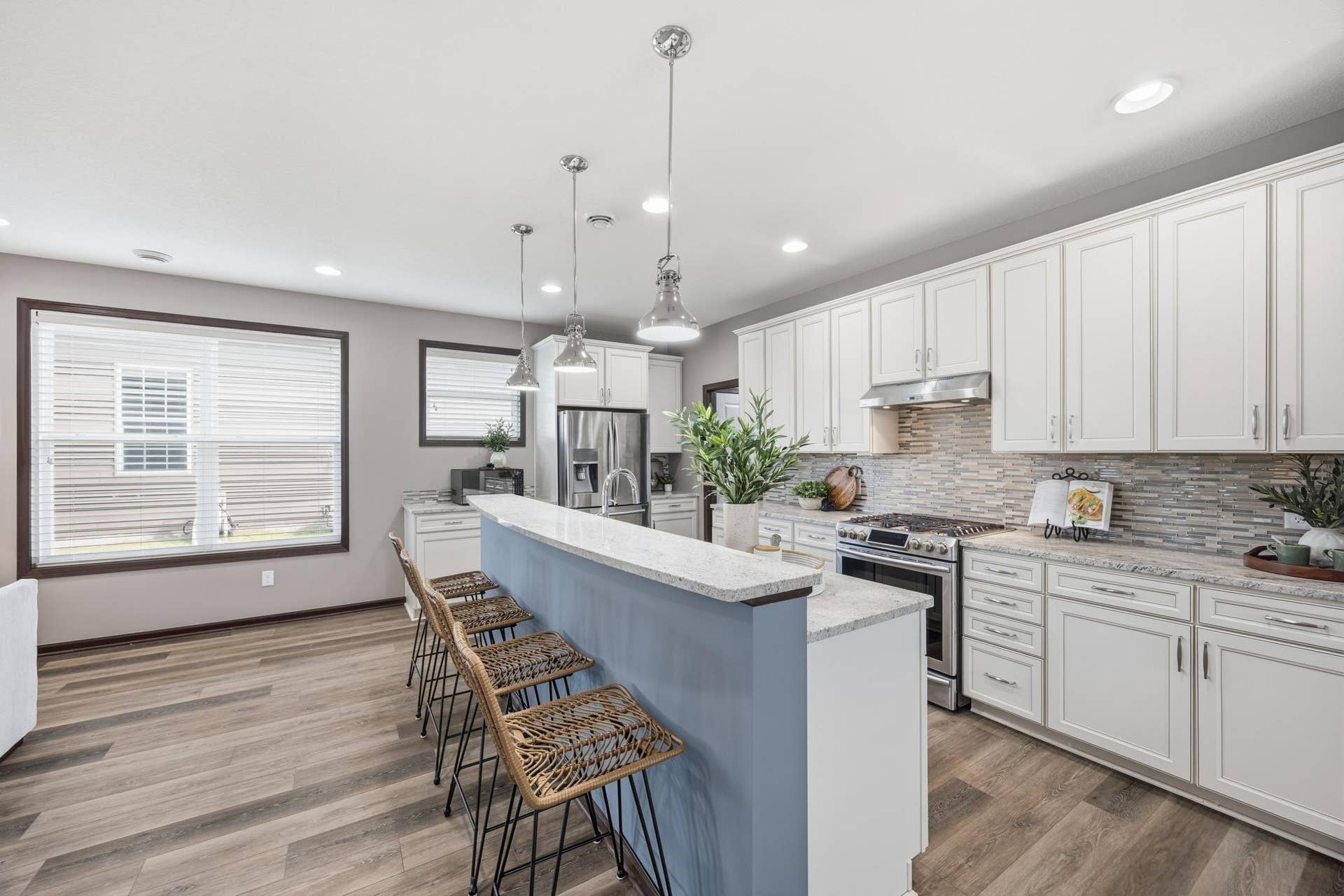 7417 Shadyview Lane N, Maple Grove, MN 55311 Bright, open kitchen featuring crisp white cabinetry, stainless steel appliances, and a spacious center island with seating.
