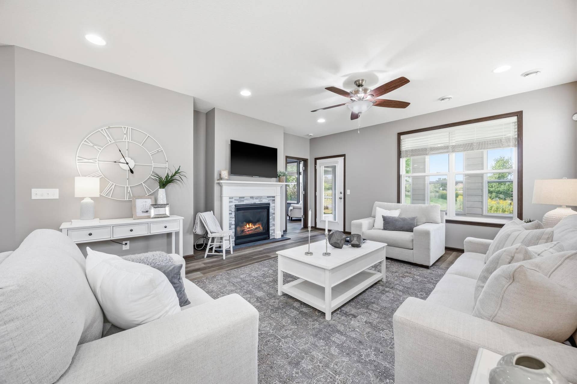 7417 Shadyview Lane N, Maple Grove, MN 55311 View of cozy gas fireplace with mounted TV and large, bright windows and access to porch and backyard and primary bedroom. All windows have Hunter Douglas window treatments.