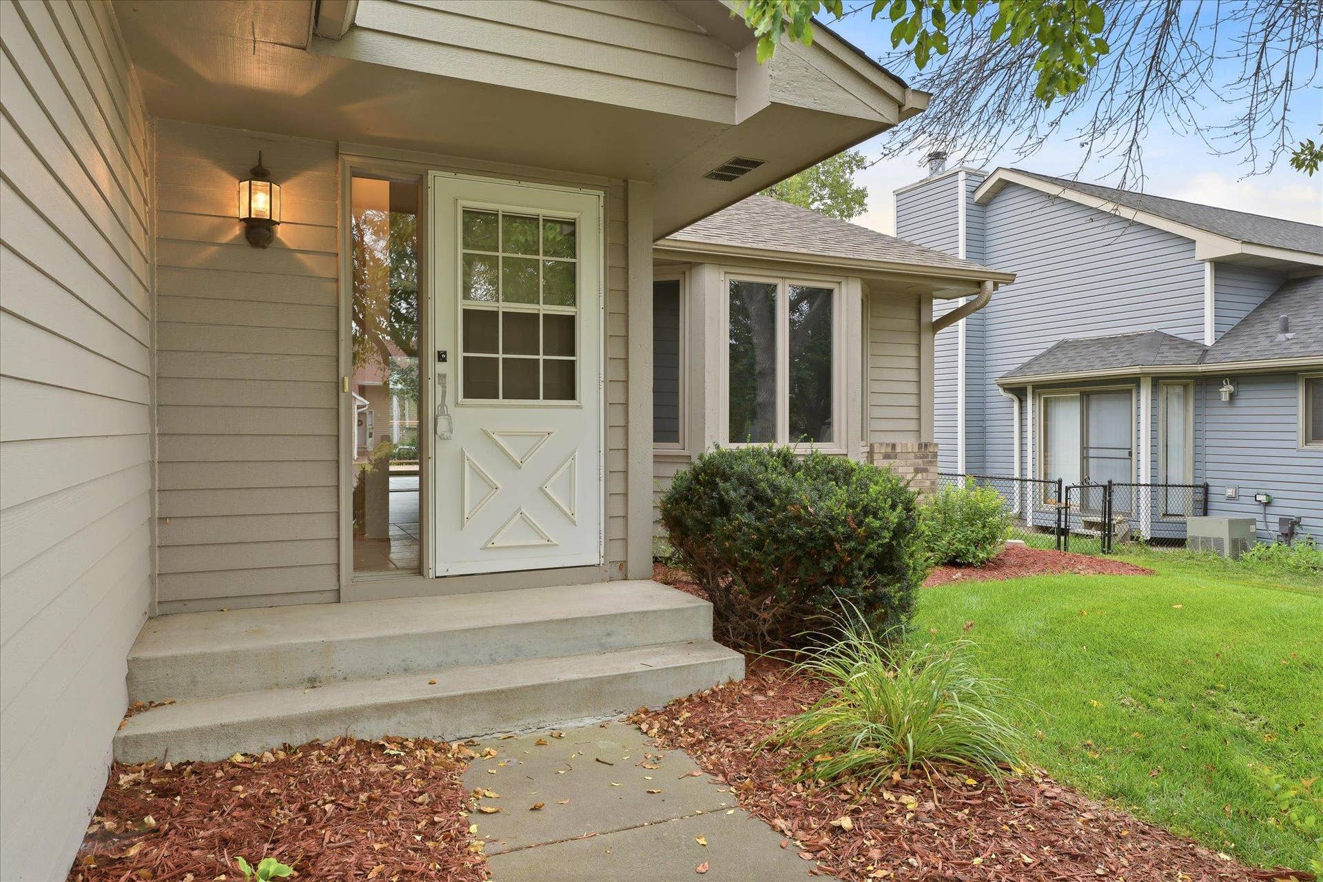 9225 Queens Gardens, Brooklyn Park, MN 55443 Welcoming front entry surrounded by professional landscaping, creating a polished and inviting approach to the home.