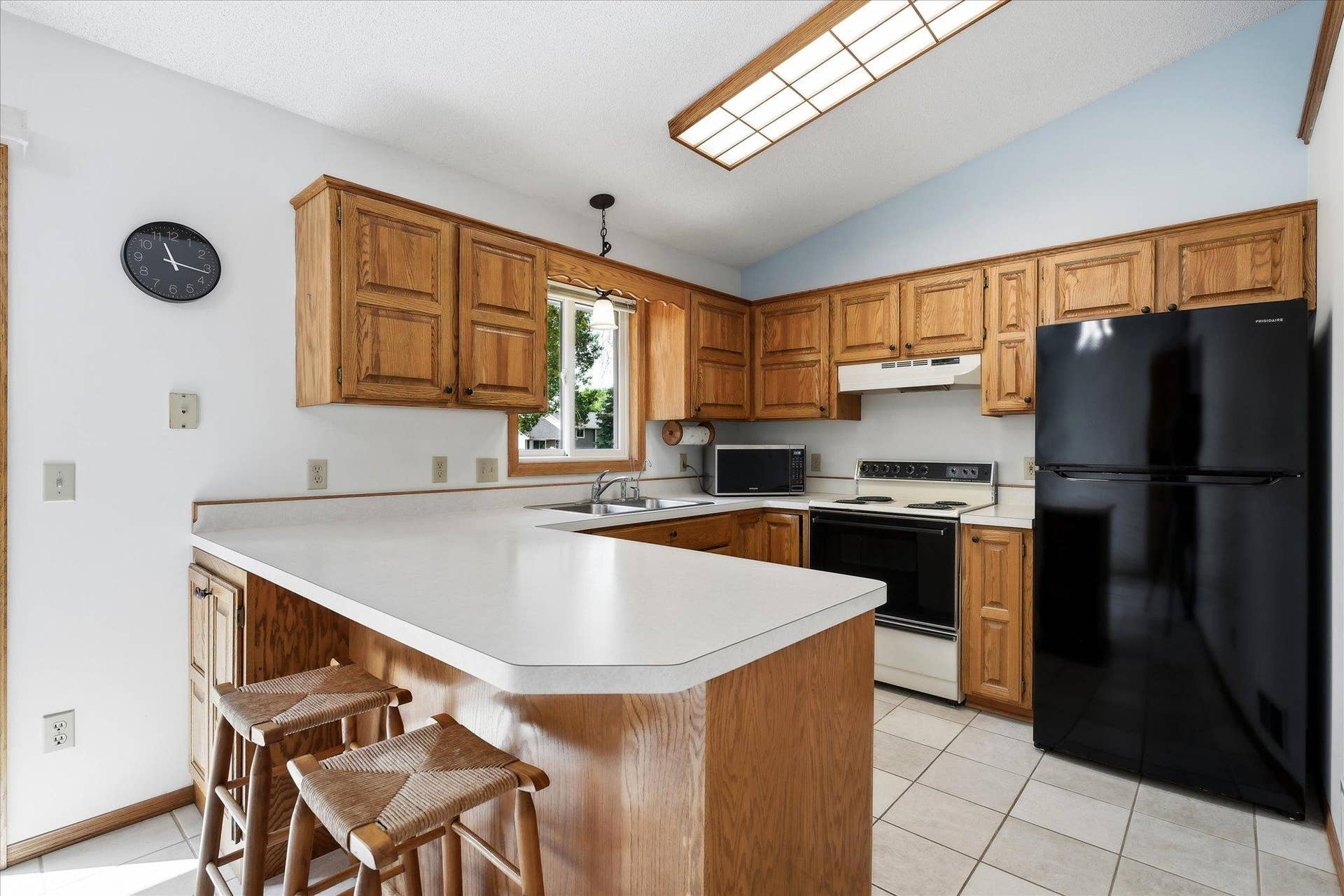 9225 Queens Gardens, Brooklyn Park, MN 55443 The kitchen offers abundant oak cabinetry and generous counter space, with a functional layout designed for everyday use.