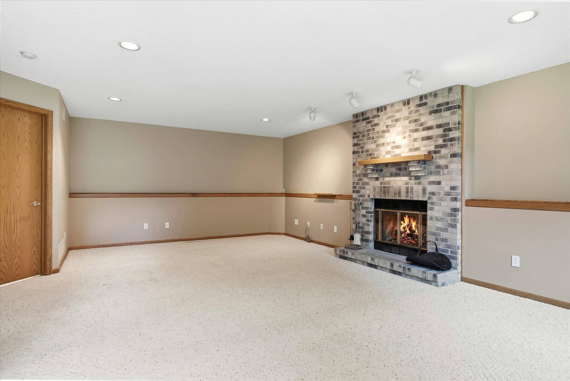 9225 Queens Gardens, Brooklyn Park, MN 55443 Spacious lower-level family room is designed for both relaxing and entertaining, featuring built-in surround sound, recessed lighting, and a continuous display ledge that wraps around the room.
