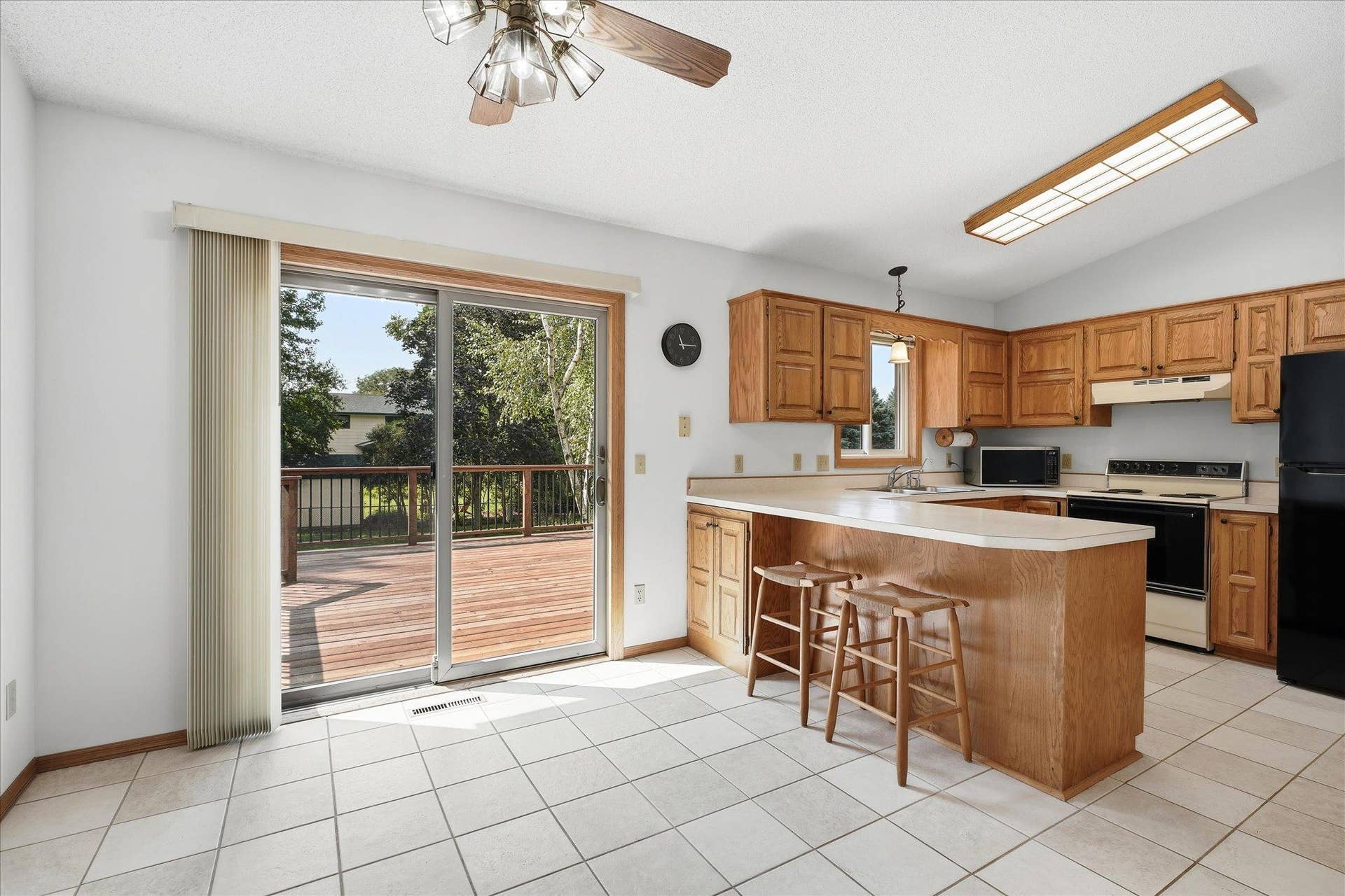 9225 Queens Gardens, Brooklyn Park, MN 55443 Comfortable dining area positioned just off the kitchen with direct access to the backyard deck for easy indoor-outdoor entertaining. Updated Anderson windows and sliding glass doors throughout the home.