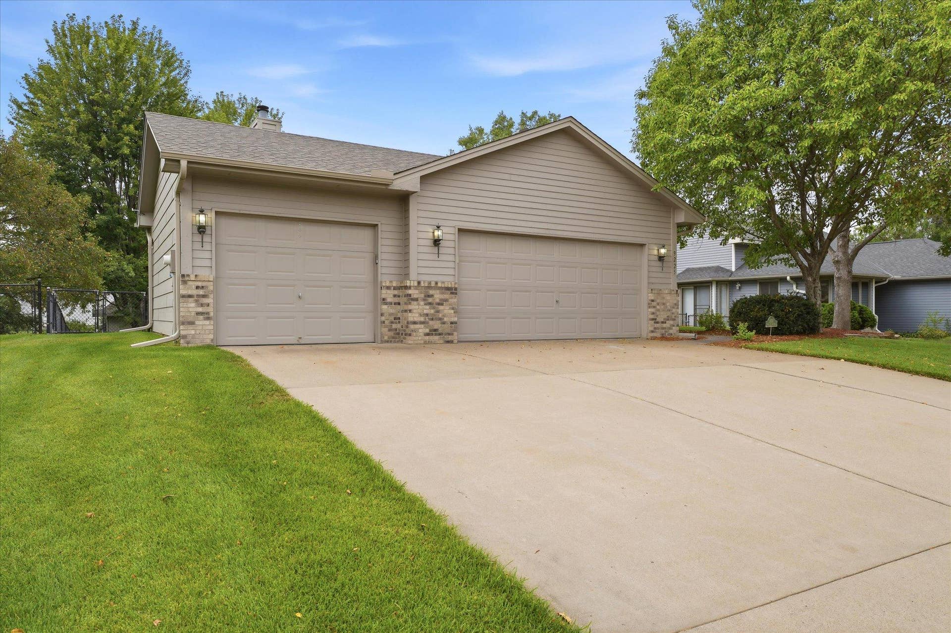 9225 Queens Gardens, Brooklyn Park, MN 55443 The extra-wide driveway leads to a spacious heated and insulated garage, ideal for Minnesota winters while providing comfortable space for vehicles, storage, hobbies, and projects year-round.