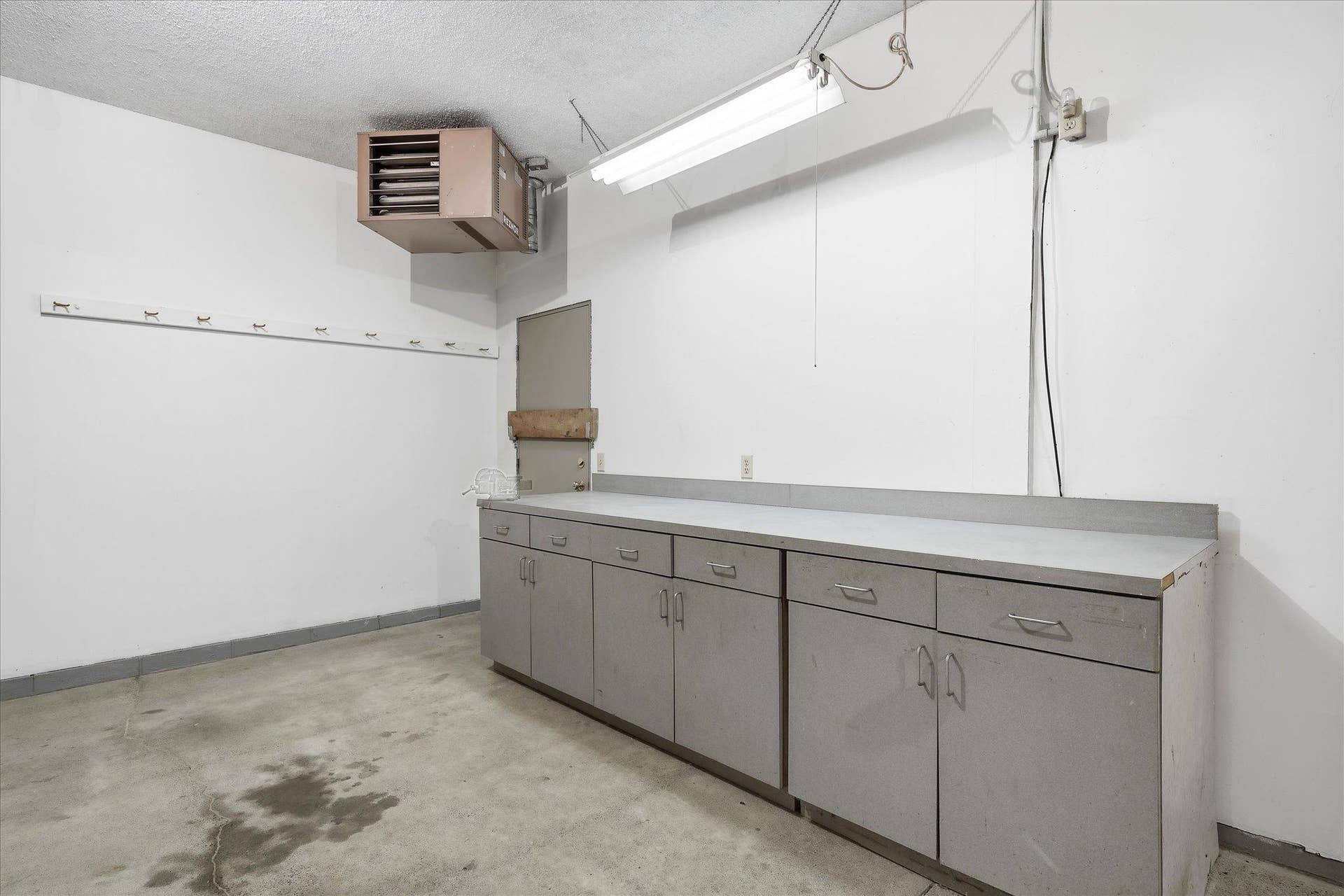 9225 Queens Gardens, Brooklyn Park, MN 55443 This impressive garage is more than just parking, featuring a workbench, hot and cold water, pull-down attic access for additional storage, 200-amp electrical service, and a 220V outlet, a fantastic setup for a workshop or hobby space.