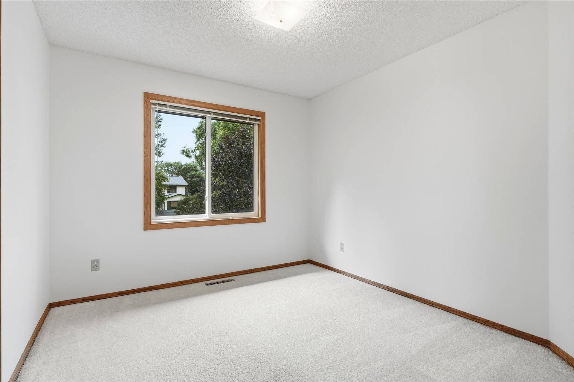 9225 Queens Gardens, Brooklyn Park, MN 55443 Generously sized second bedroom with a large window and plenty of flexibility for furniture placement.