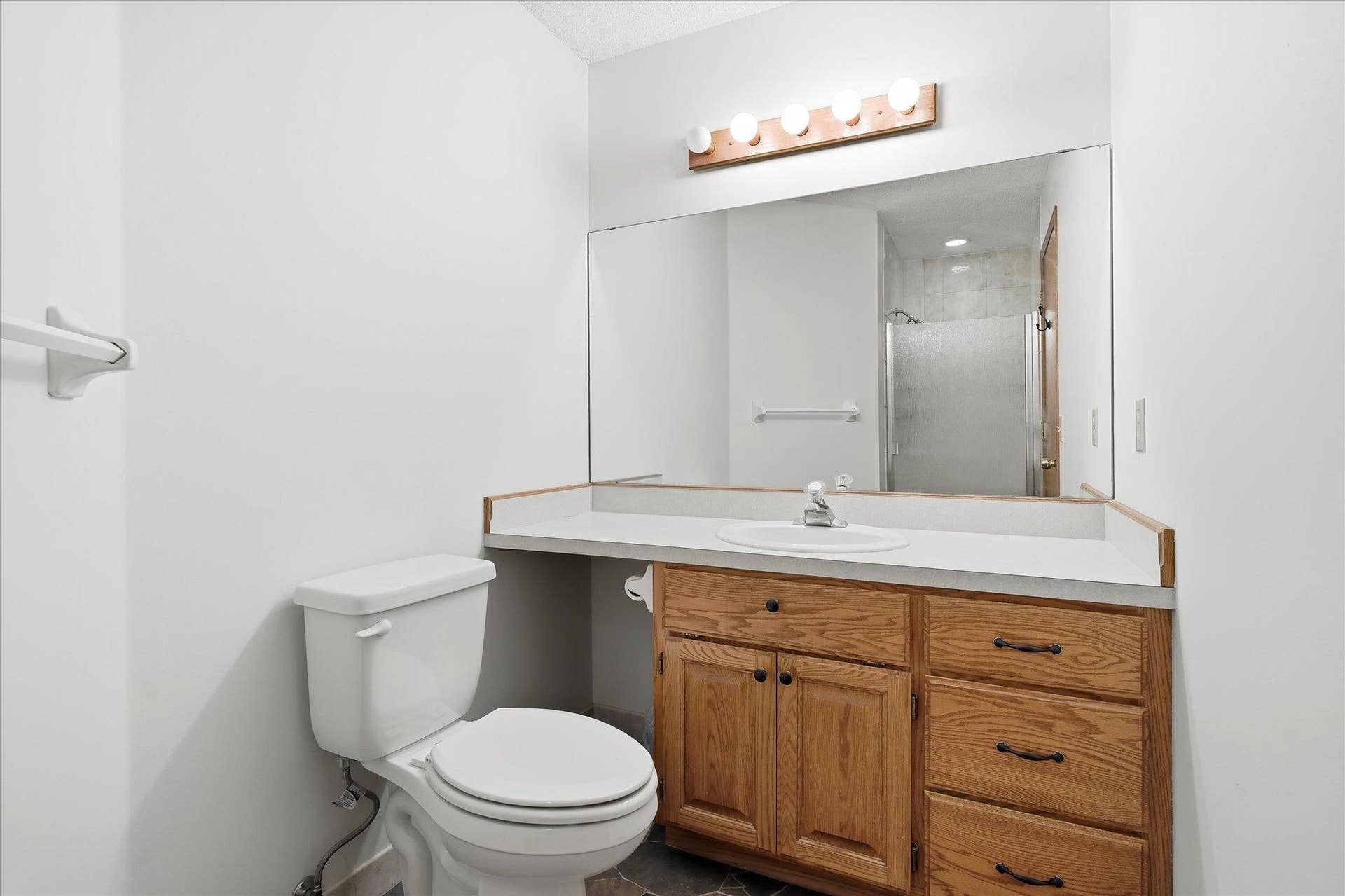9225 Queens Gardens, Brooklyn Park, MN 55443 Private primary bath features a walk-in shower, vanity storage, and a bright, well-maintained finish.