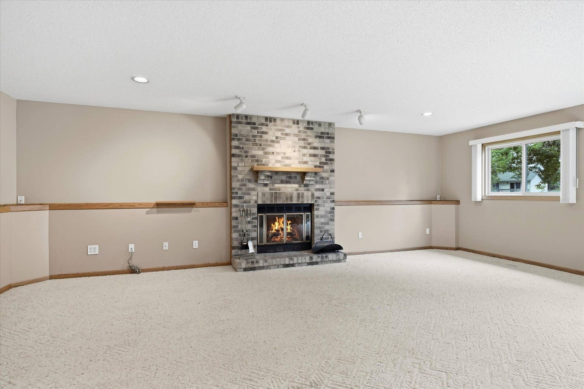 9225 Queens Gardens, Brooklyn Park, MN 55443 The striking brick wood-burning fireplace positioned in the center of the lower-level family room creates a warm, inviting focal point while adding character to the spacious entertaining area.