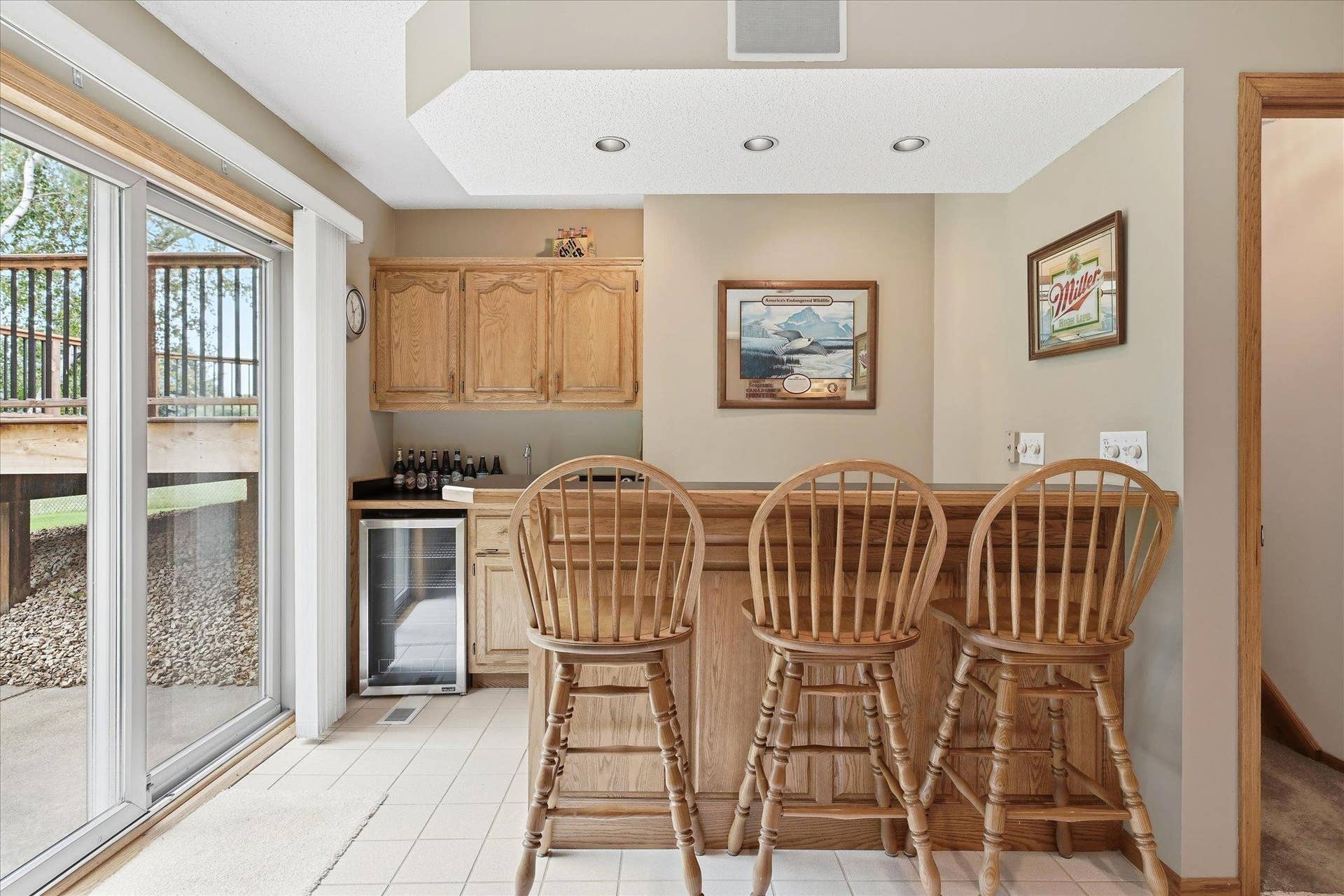 9225 Queens Gardens, Brooklyn Park, MN 55443 The lower-level wet bar is ready for entertaining, featuring a built-in refrigerator, tile flooring, ample cabinetry and counter space, plus recessed accent lighting that adds a warm ambiance to the space.