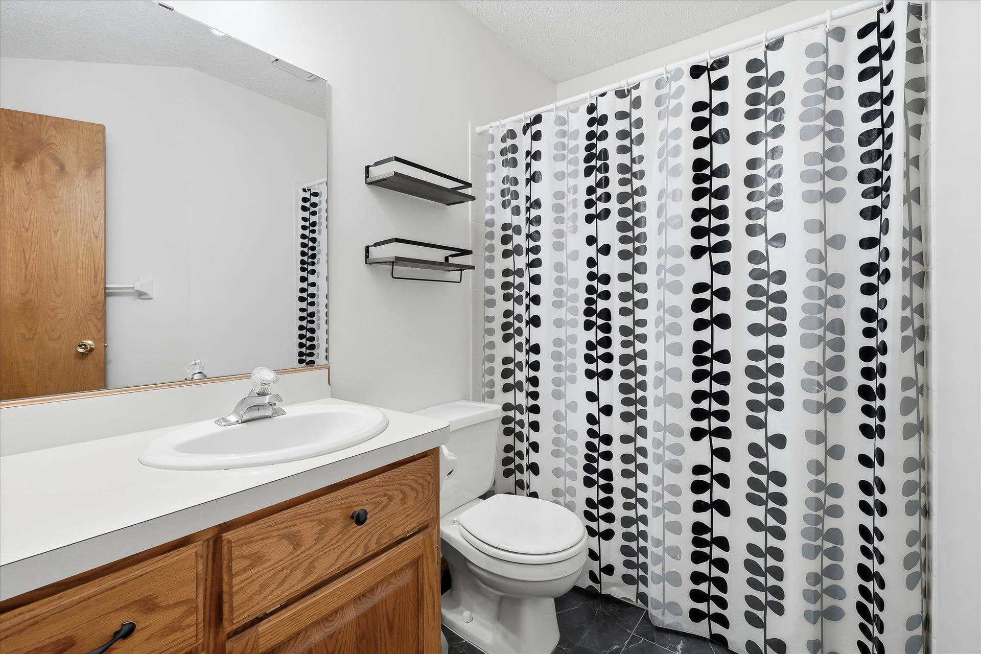 9225 Queens Gardens, Brooklyn Park, MN 55443 Upper-level full bath features a spacious vanity with plenty of storage and a clean, neutral design.