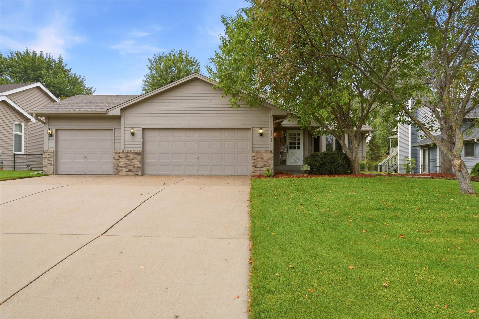 9225 Queens Gardens, Brooklyn Park, MN 55443 Beautiful curb appeal welcomes you to 9225 Queens Garden N, featuring updated Anderson windows and doors, gutters, newer roof, professional landscaping, and a spacious extra-wide concrete driveway offering plenty of parking.