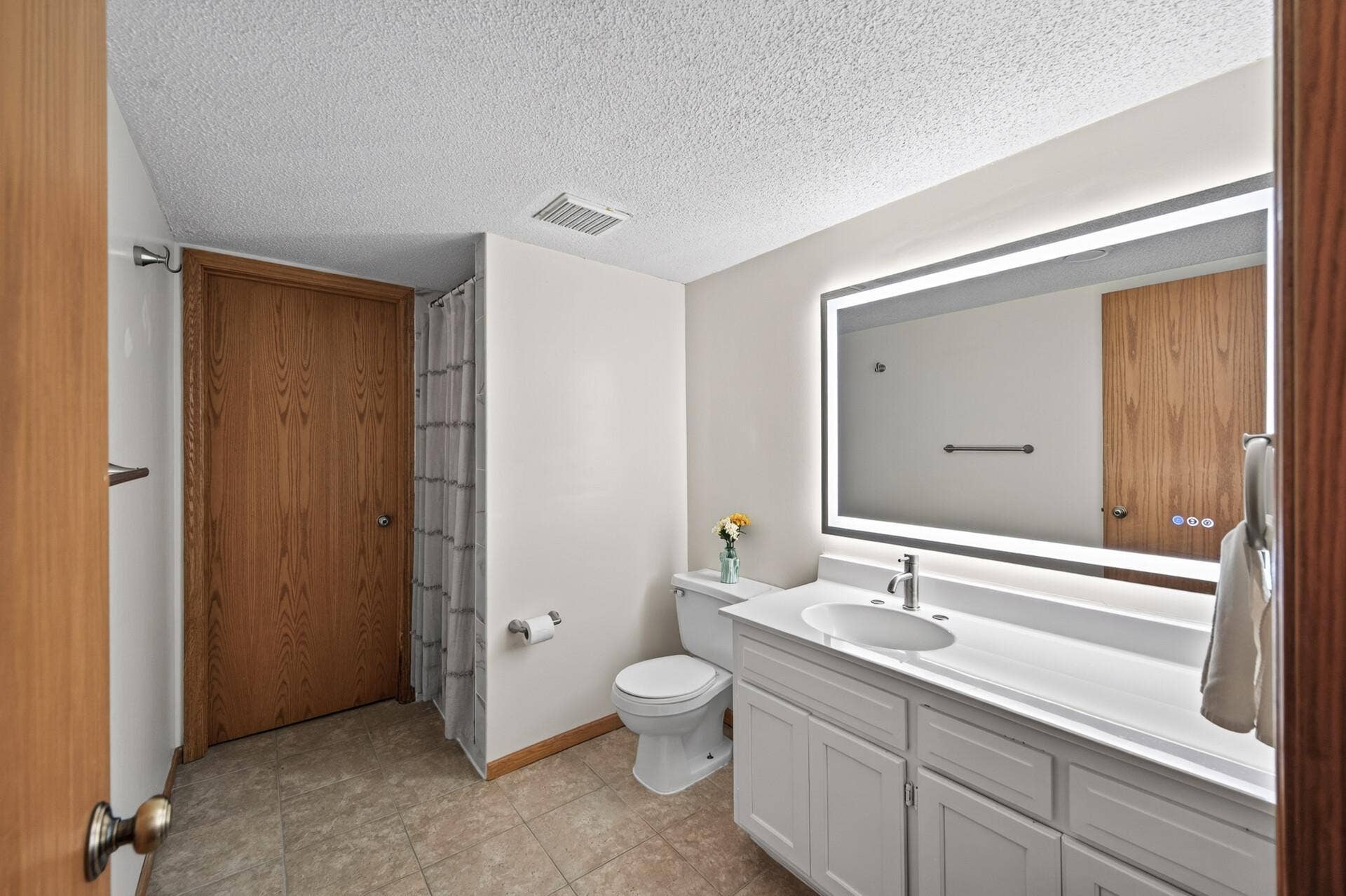 6865 Romeo Road, Woodbury, MN 55125 The additional bathroom adds everyday convenience to the lower level and features a spacious vanity with plenty of storage and beautifully tiled shower.