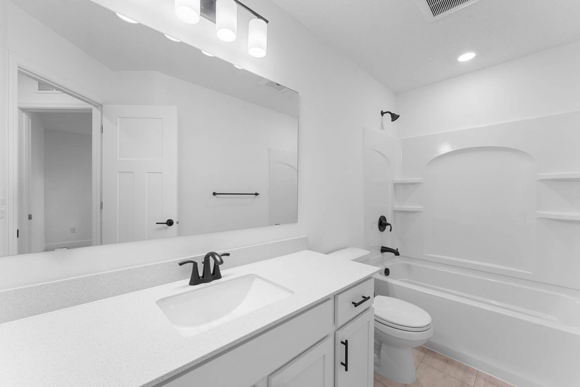This full second-floor bathroom features a wide single vanity and shower-tub combination.