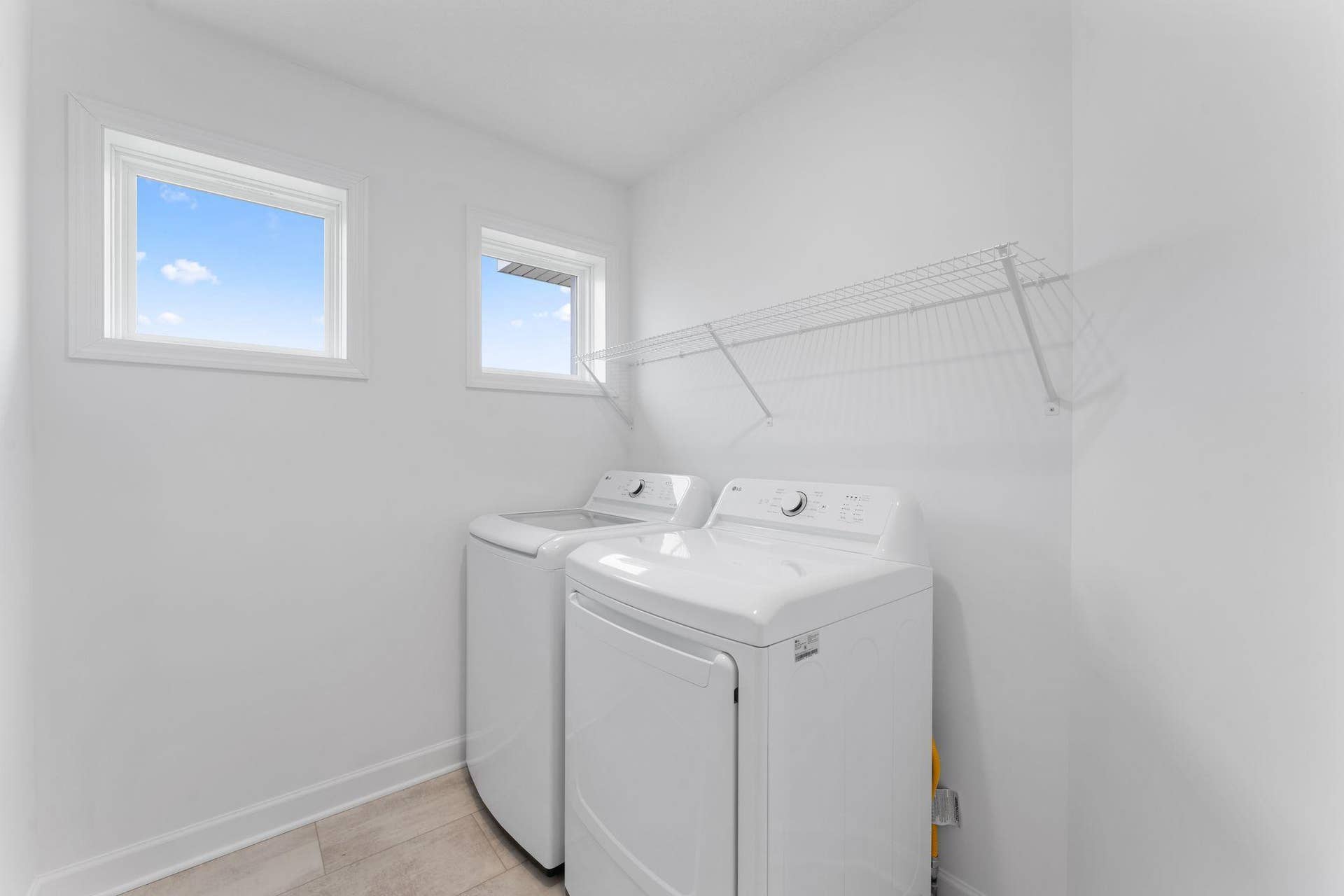 The laundry room features washer and dryer hook-ups and shelving for storage.