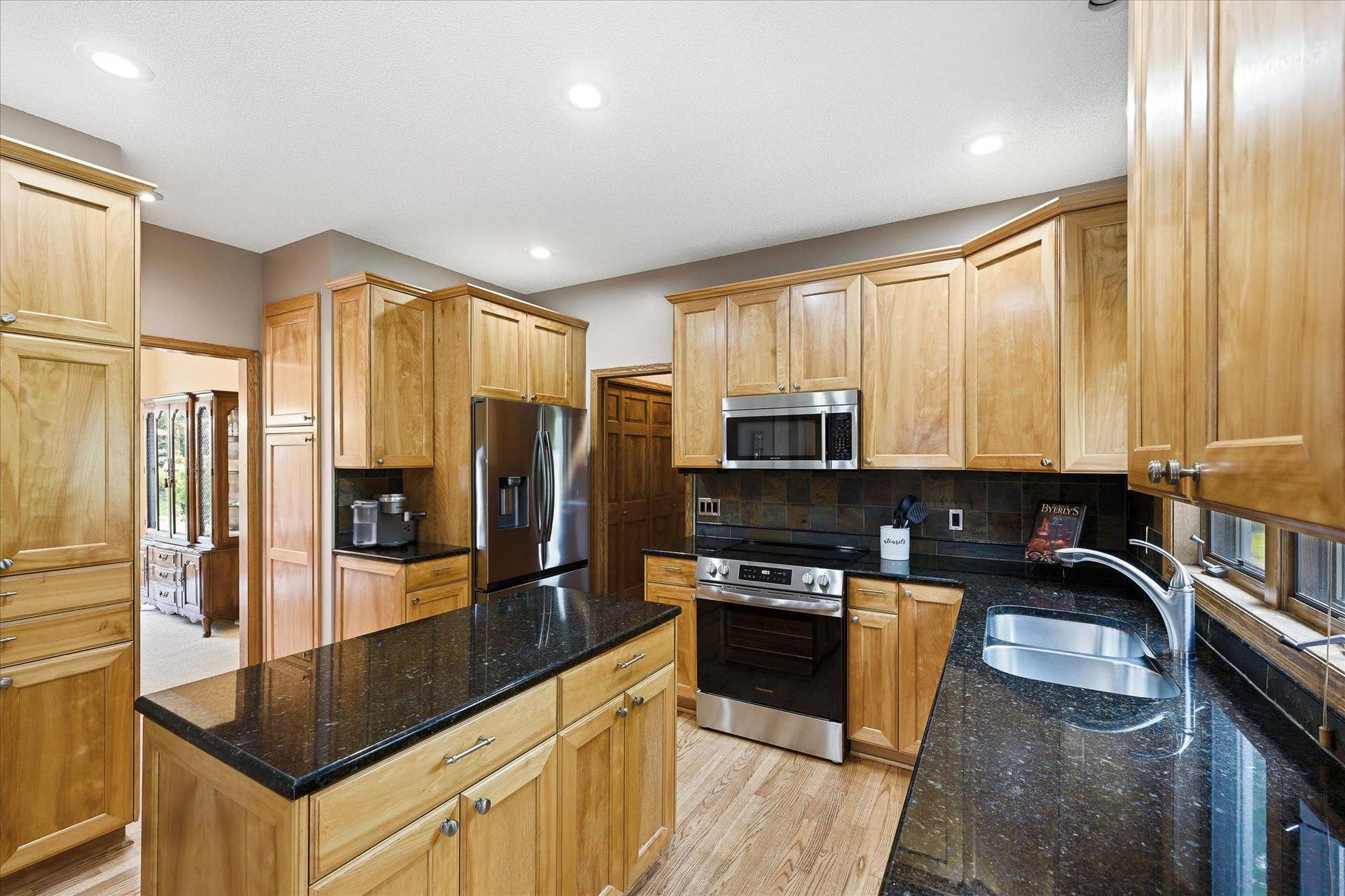 11412 Louisiana Avenue S, Bloomington, MN 55438 The remodeled kitchen features generous cabinetry, beautiful countertops, and a center island with plenty of room for meal preparation and gathering.