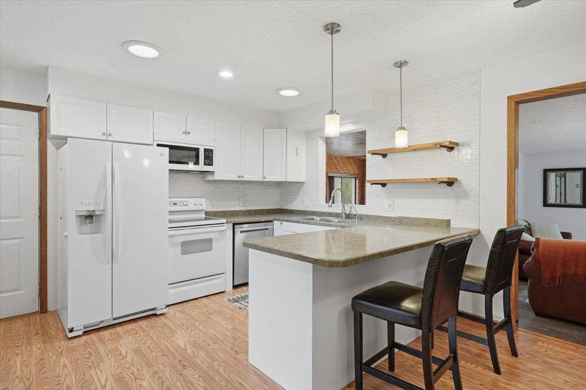 272 Glenmont Road, River Falls, WI 54022 Bright and crisp kitchen featuring white cabinetry, lots of counter space and a breakfast bar.
